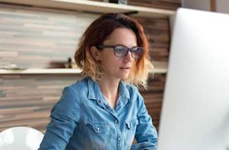 [Featured image] A product strategist in a blue shirt works in front of a large computer monitor.