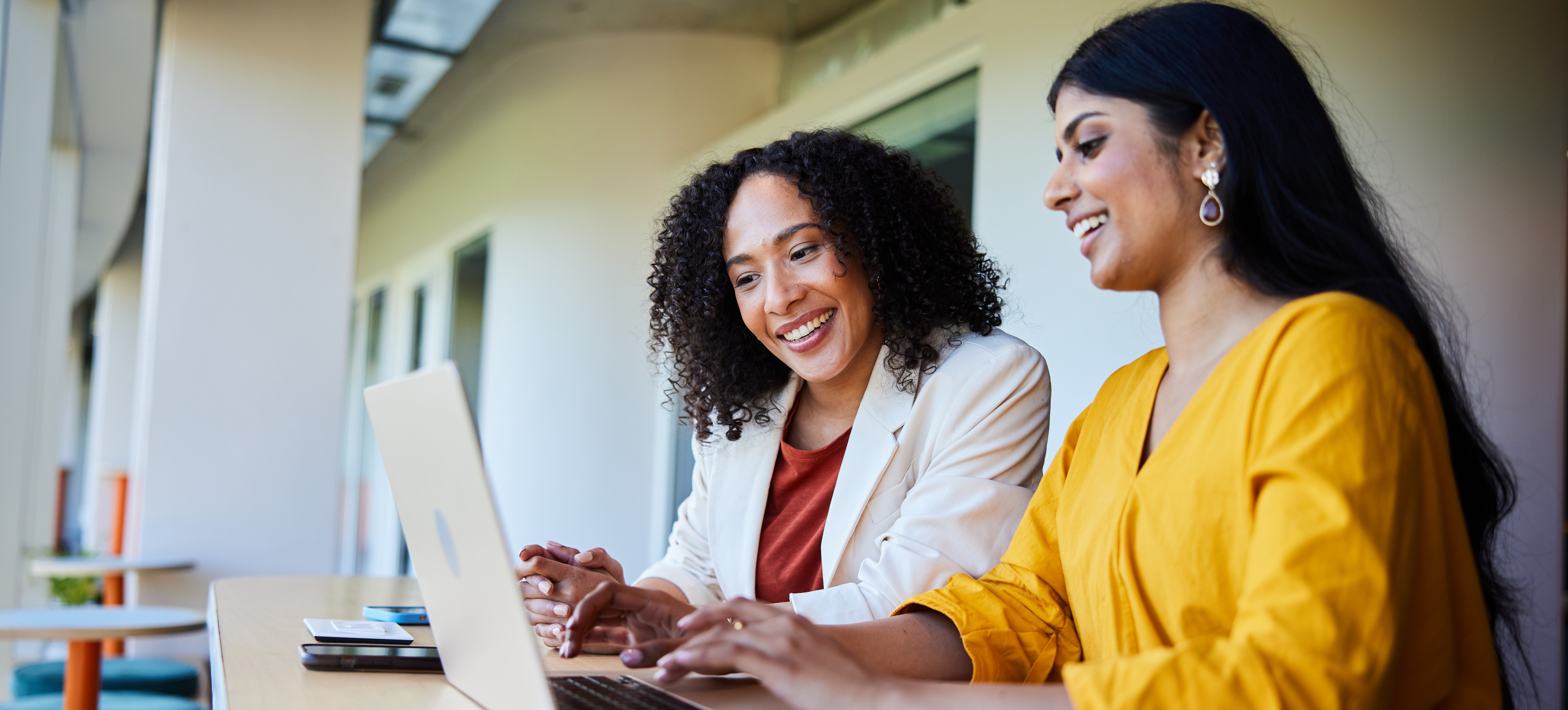 [Featured Image] Two people sit at a laptop and use the e-commerce platform Shopify to sell their business’s products to an online audience. 
