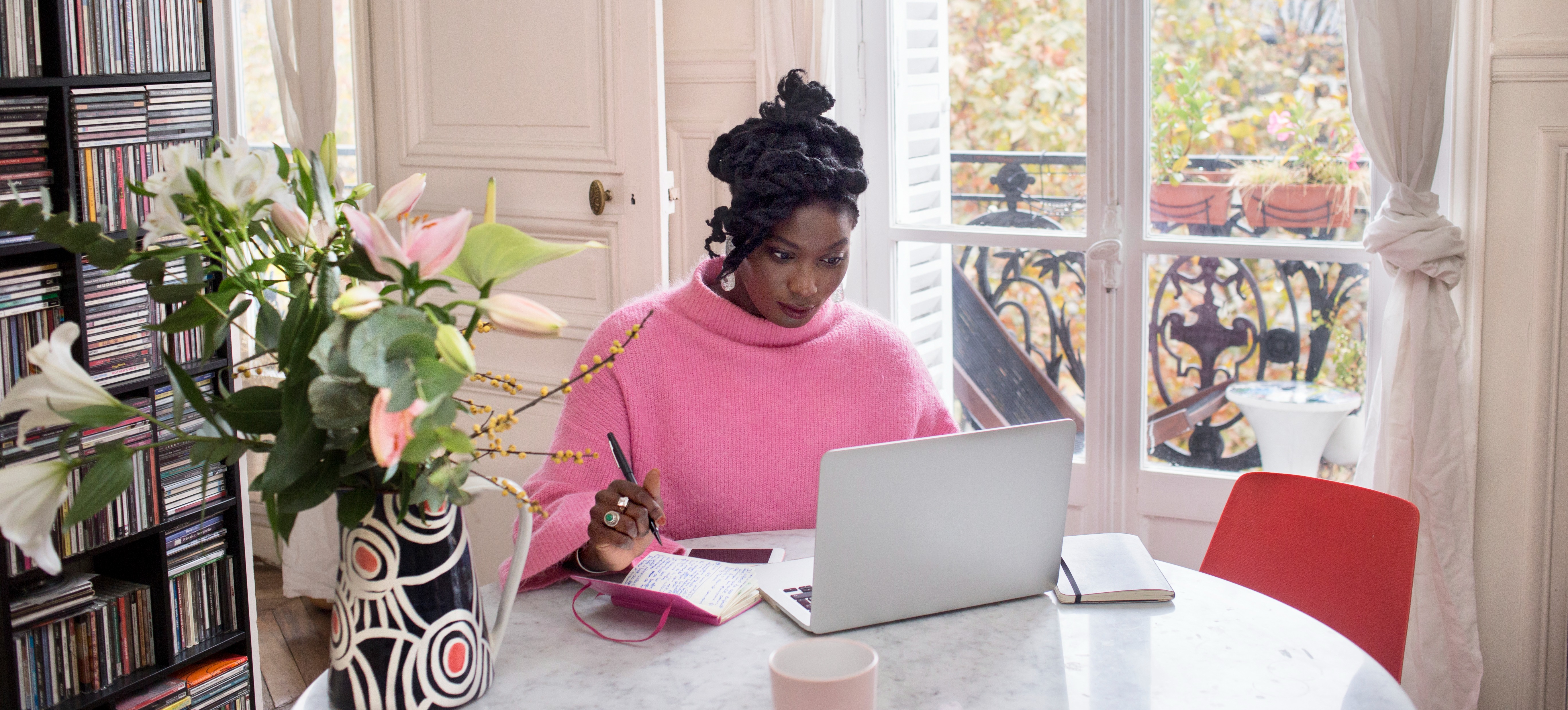 [Featured image] A learner studies for an online degree on their laptop while sitting at a dining room table at home.