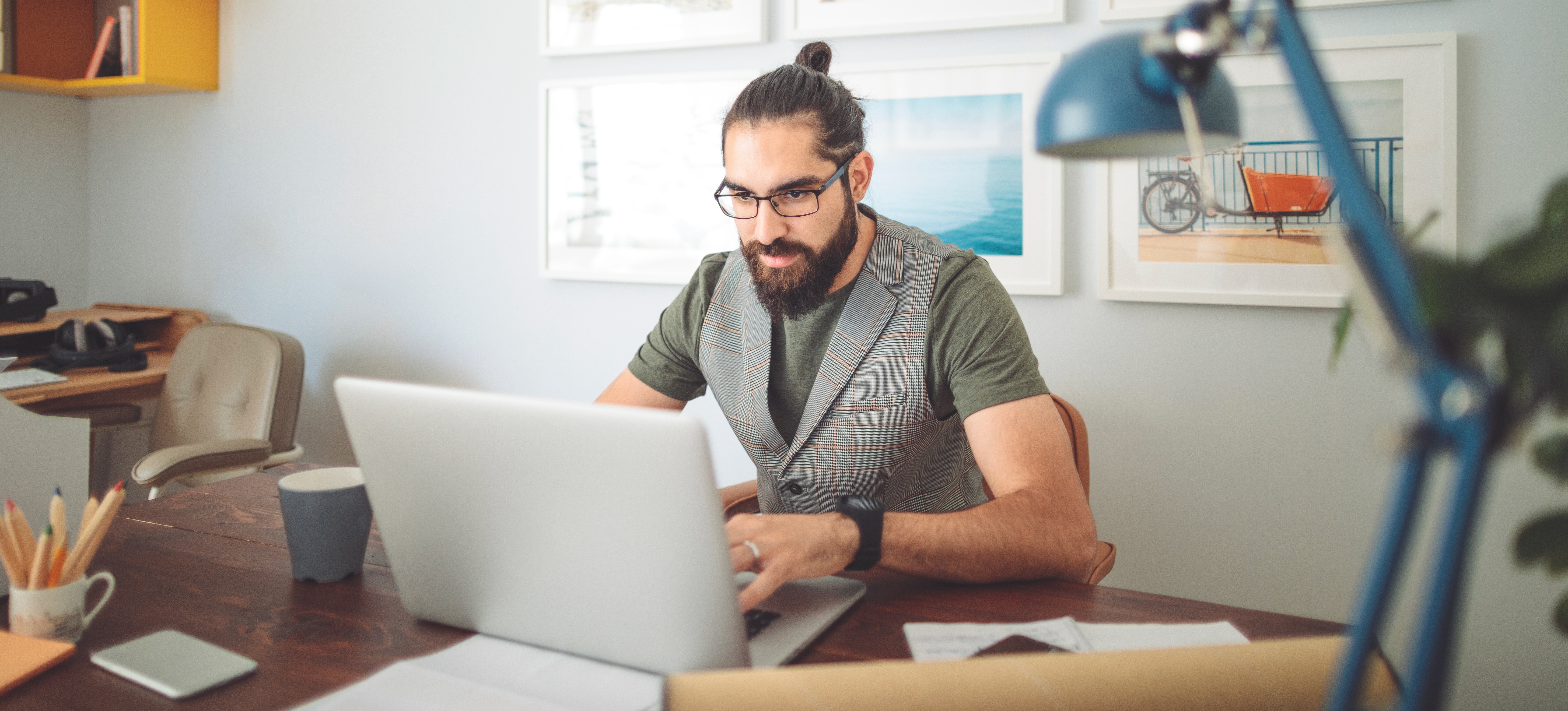 [Featured Image] A person works at his desk, typing on his laptop and learning about digital skills.