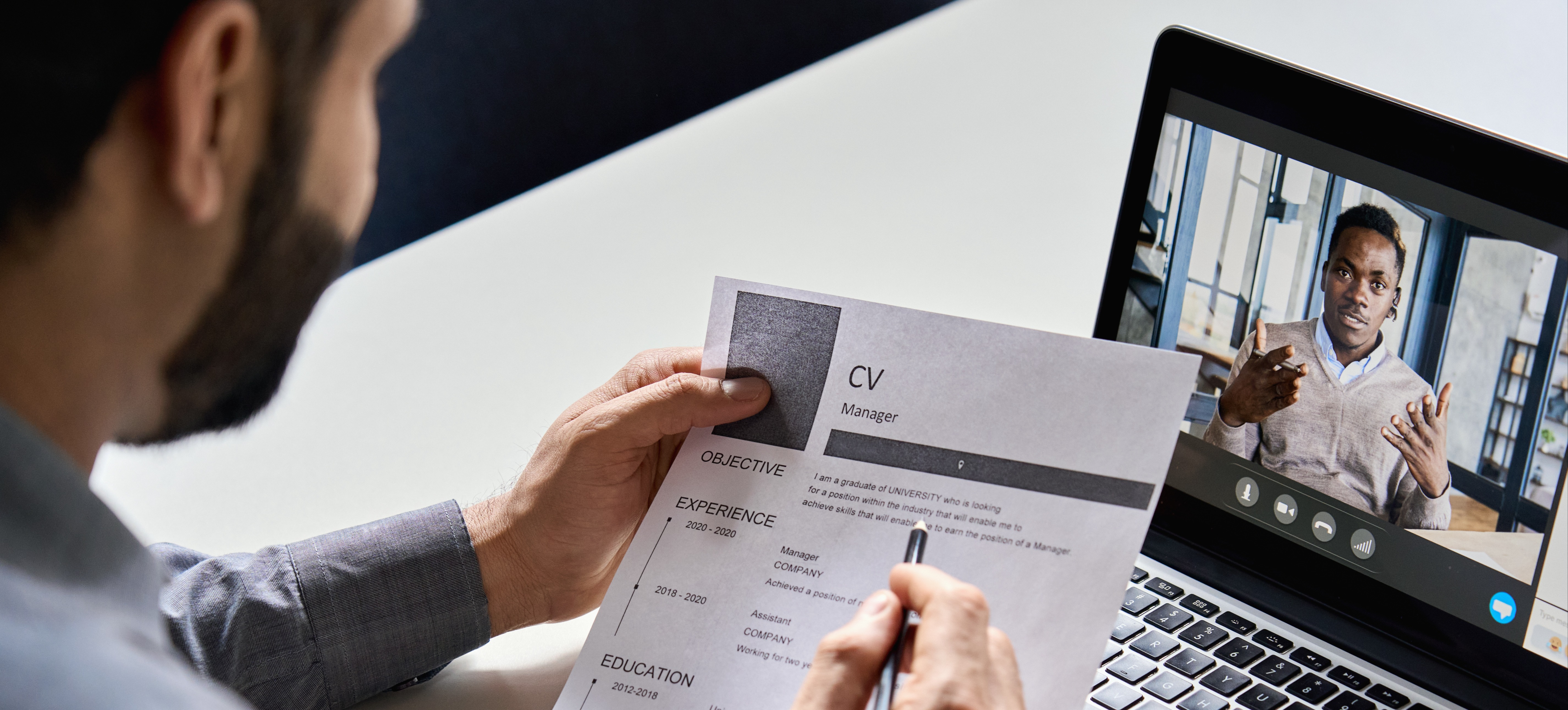 [Featured Image] A hiring manager reviews a CV and cover letter during a video interview.
