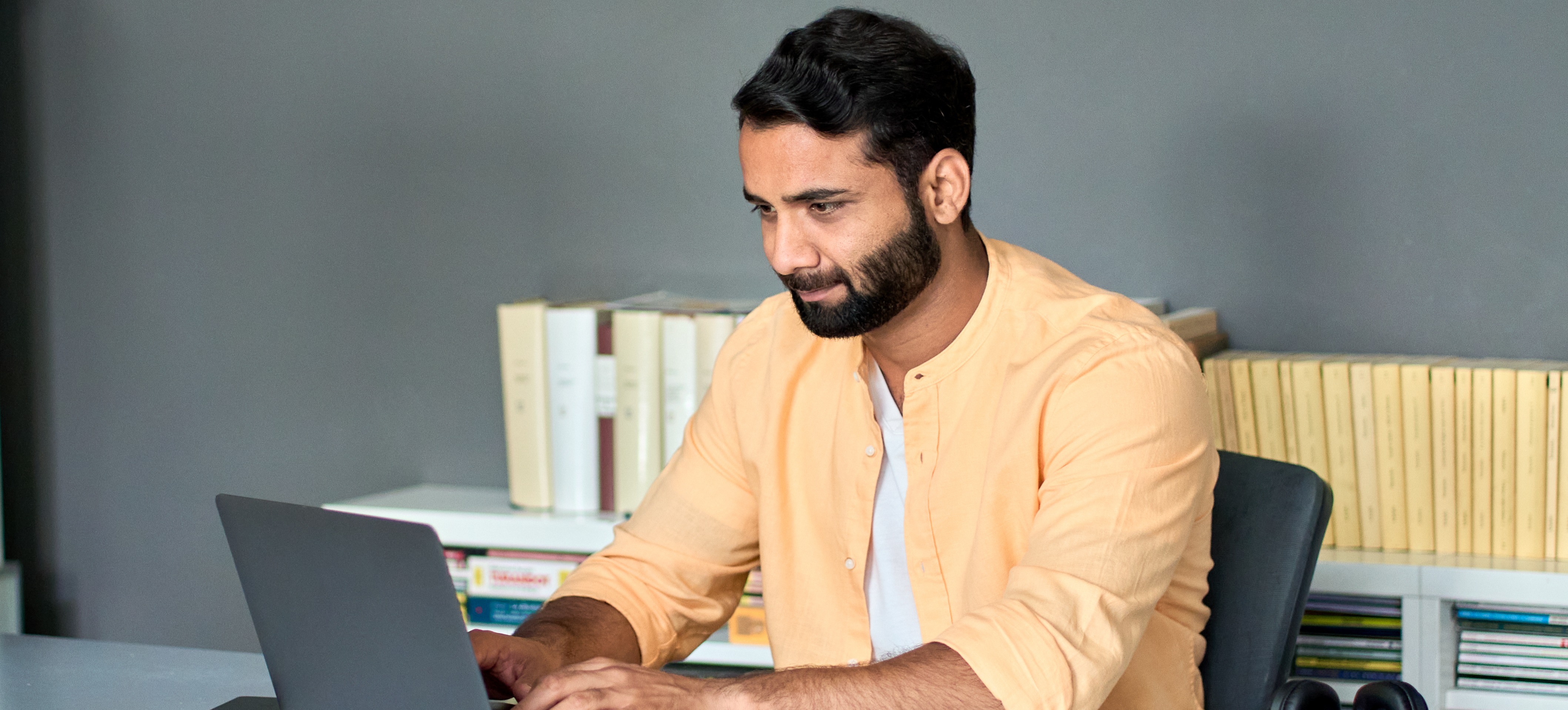 [Featured Image] A man sits at a laptop and earns his MBA in data science.
