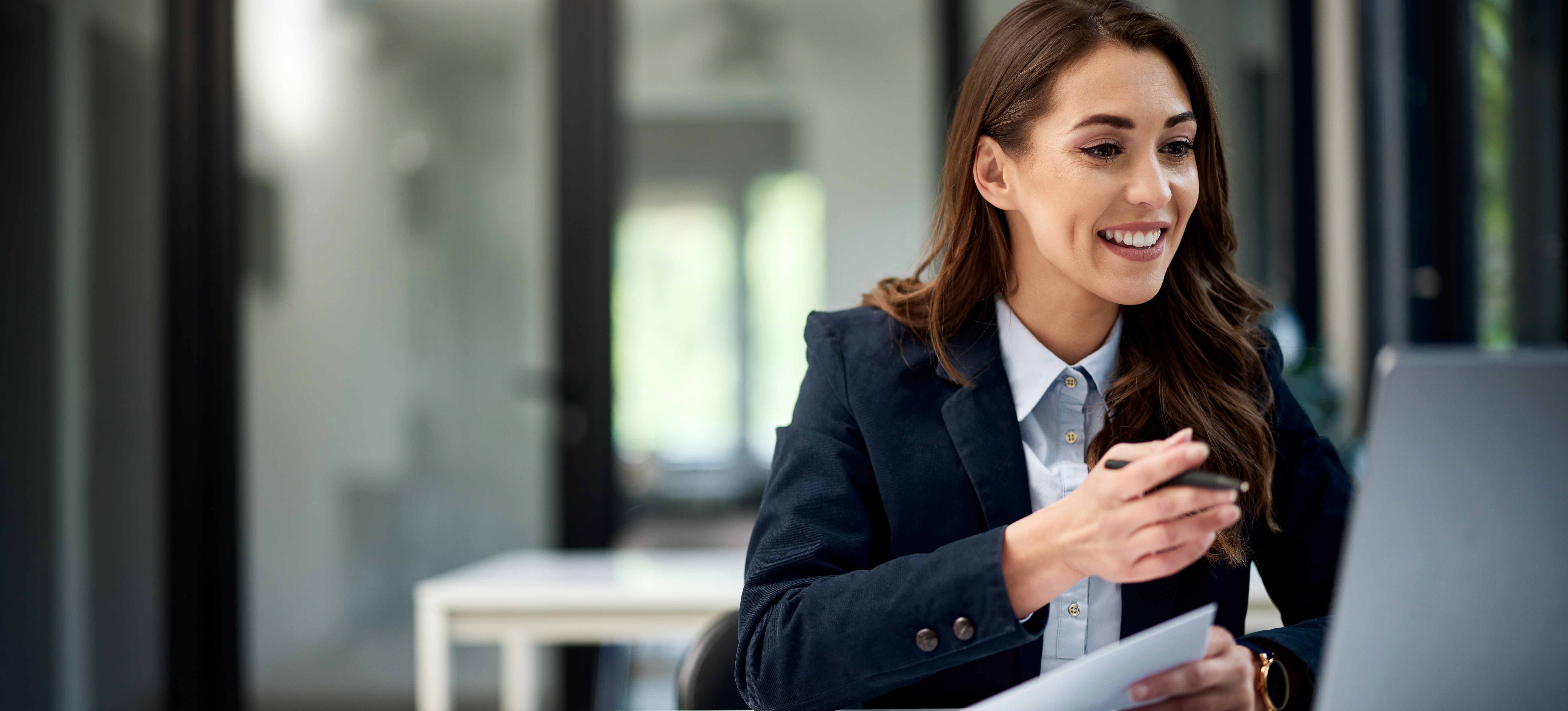 [Feature Image] A dark-haired professional researches the average cloud computing salary on a laptop while considering a possible career change. 
