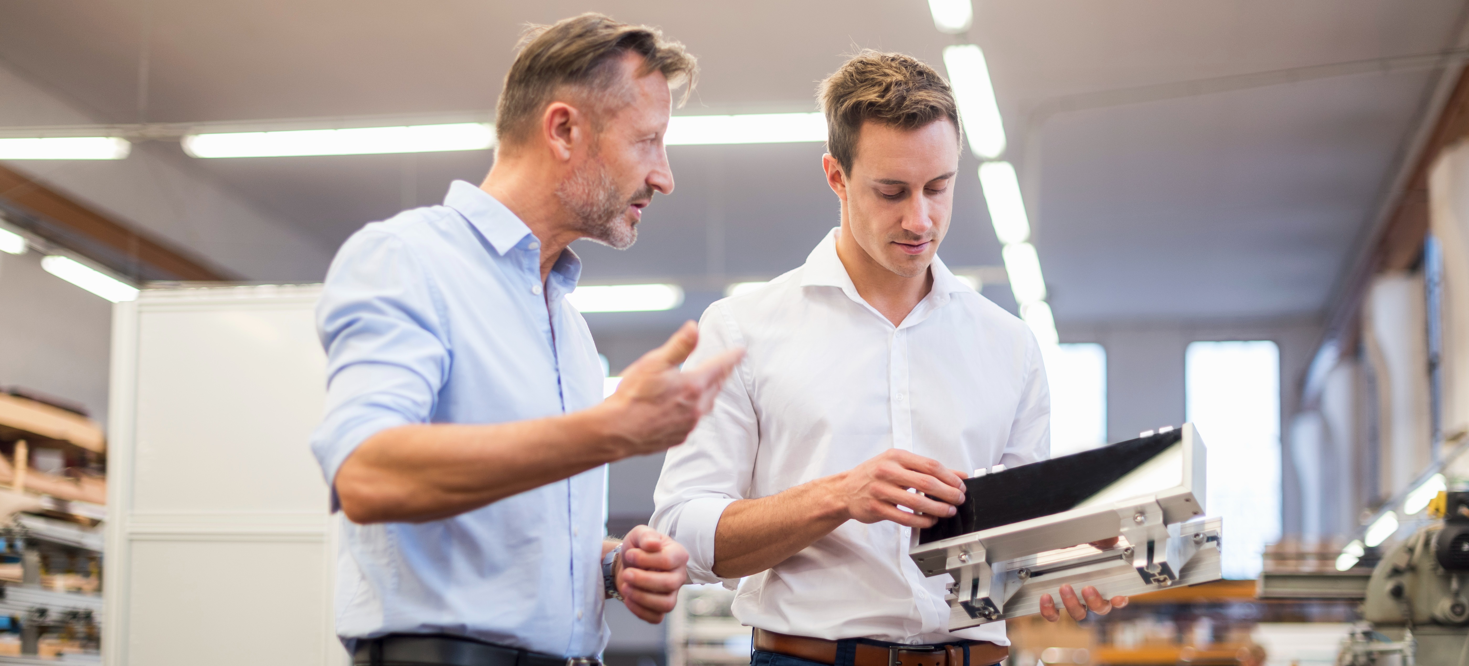 [Featured Image] A product specialist ensures a colleague understands the functionality of the product their company sells.   
