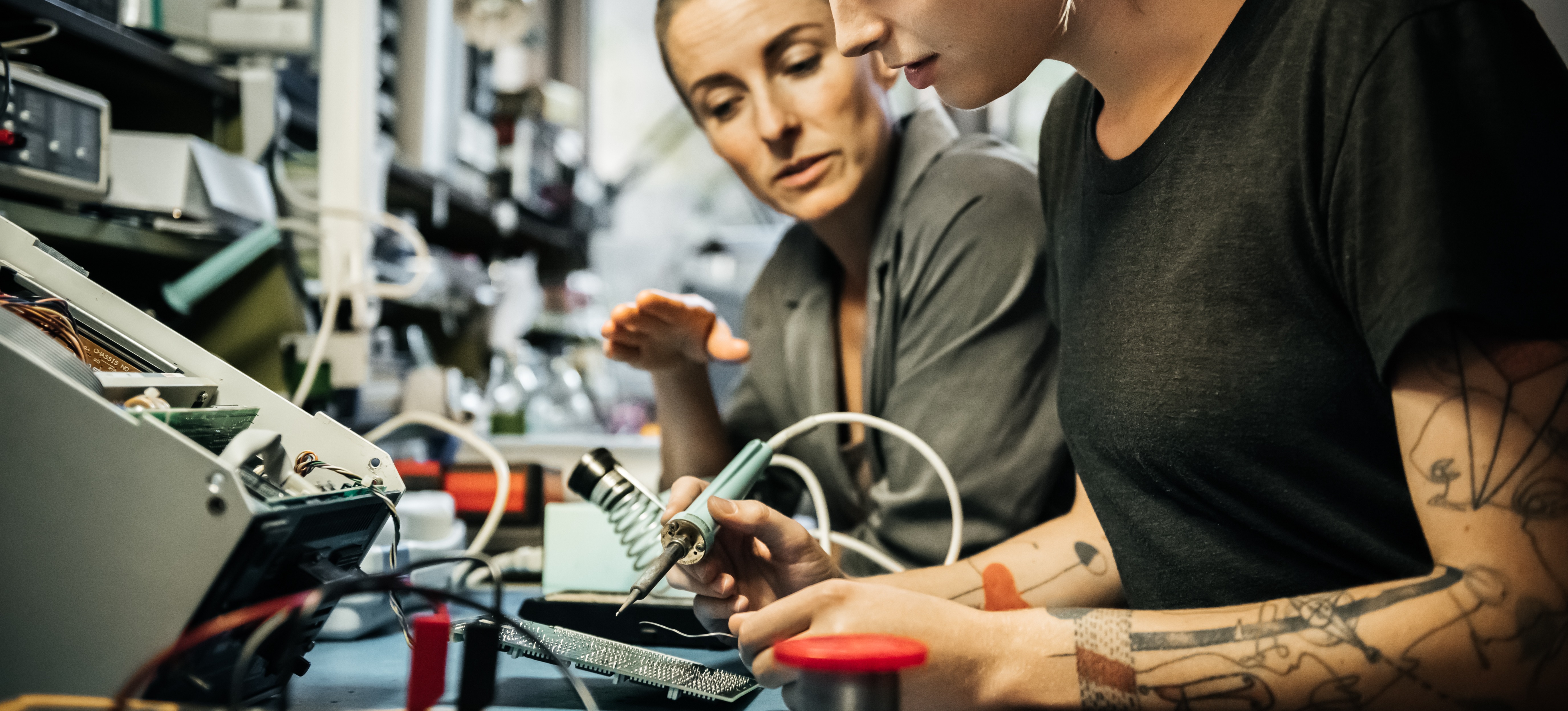[Featured Image] A hardware engineer is training a student on the manufacturing and testing a hardware design.