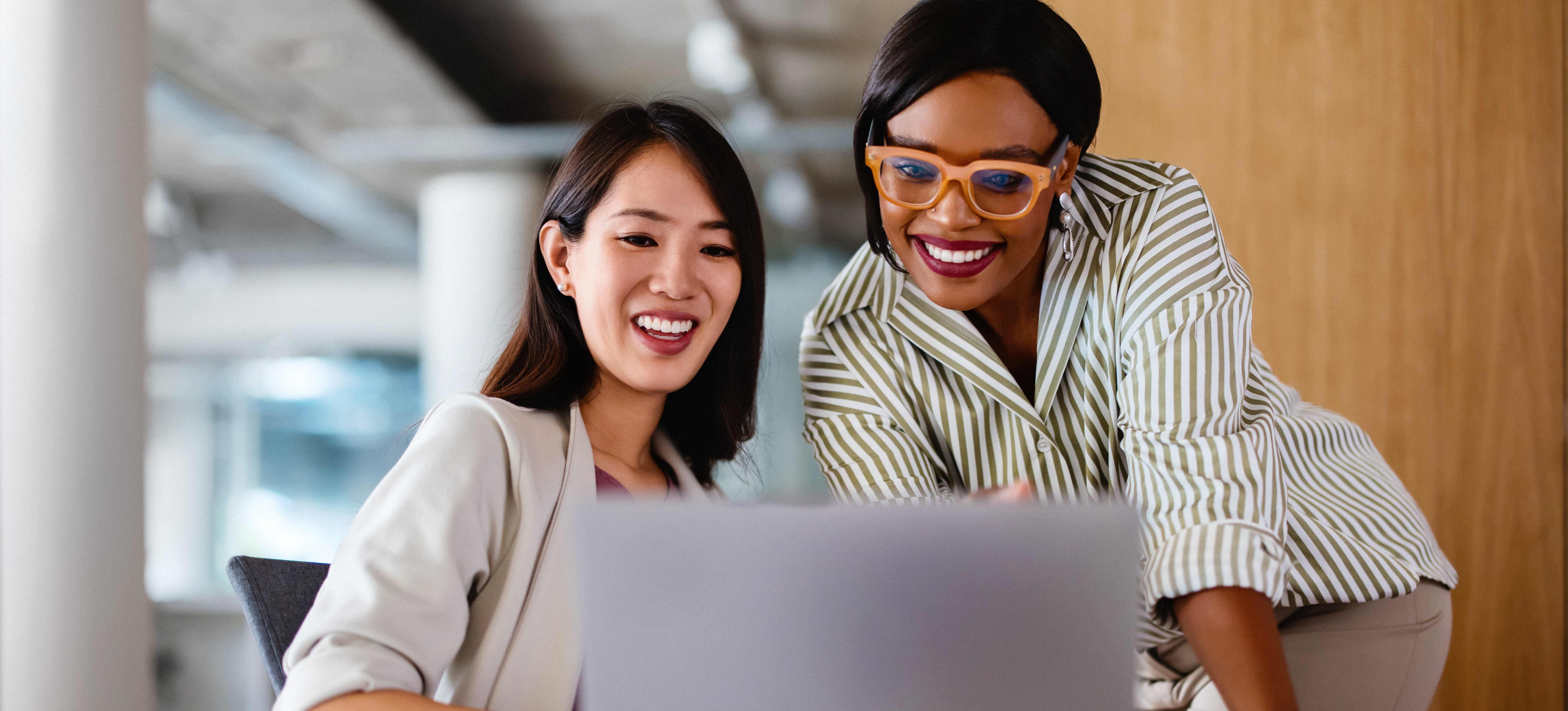 [Feature Image] Two businesspeople discuss the results of their customer segmentation analysis on a laptop and plan ongoing strategies.