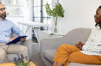 [Featured Image] A therapist talks with a patient after earning his degree.