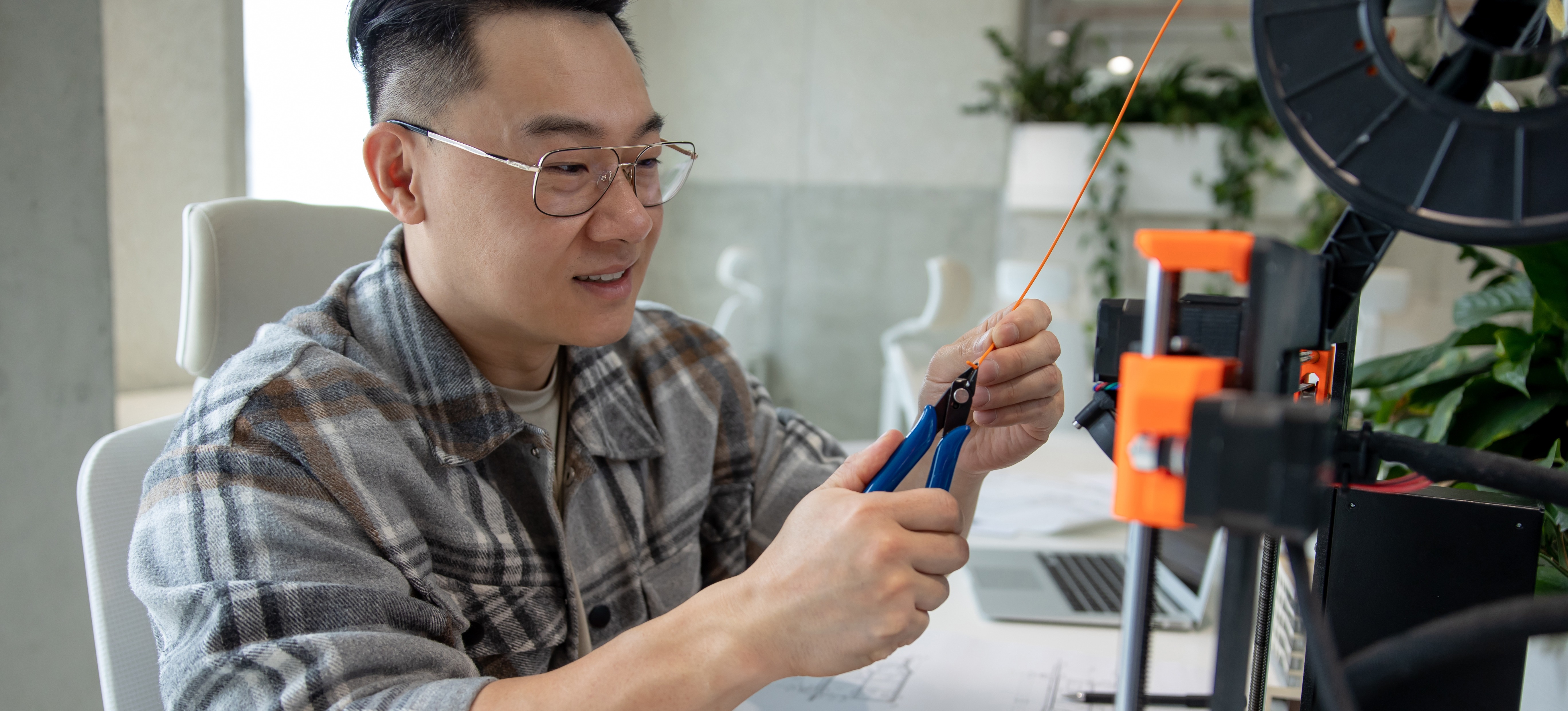 [Featured Image] An engineer uses wire cutters to cut an orange wire as they work on creating an MVP.
