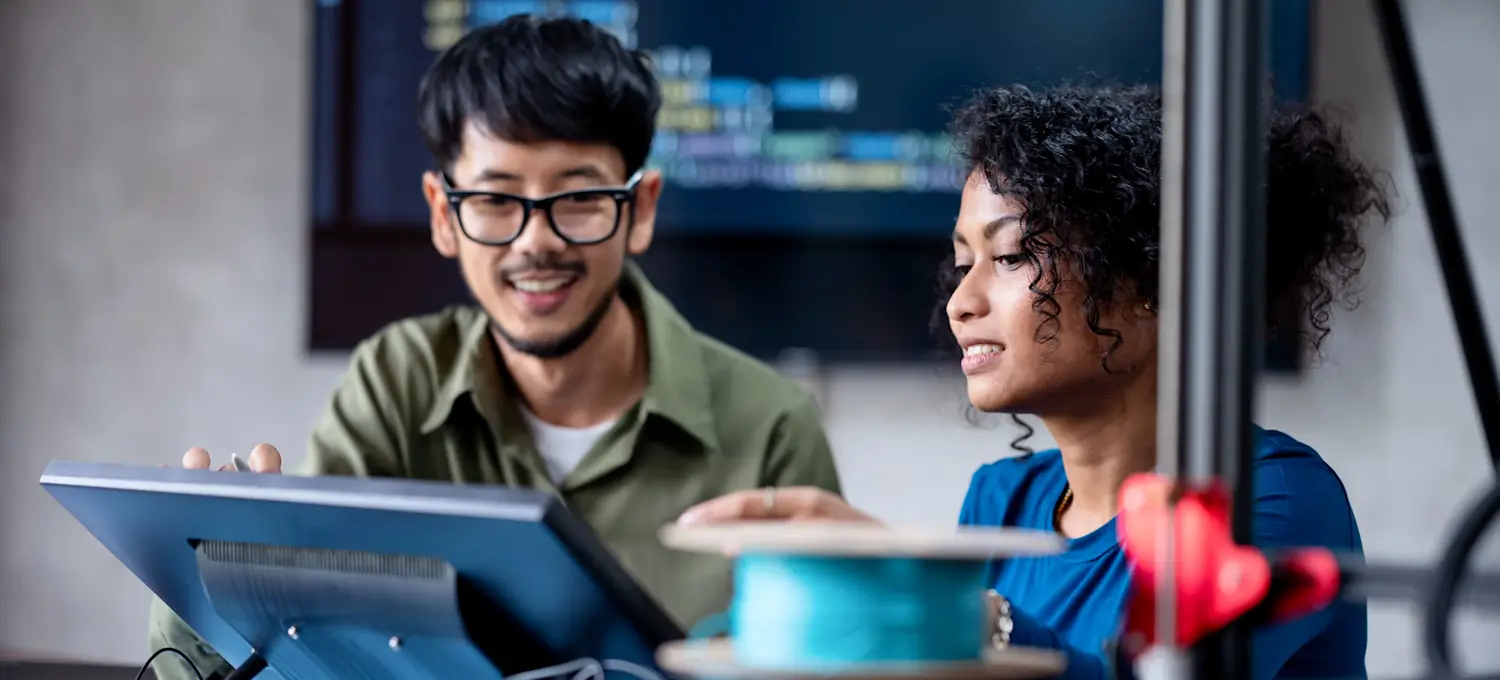 [Featured image] Two engineers looking at a small screen and discussing learning rates to train a deep learning model.