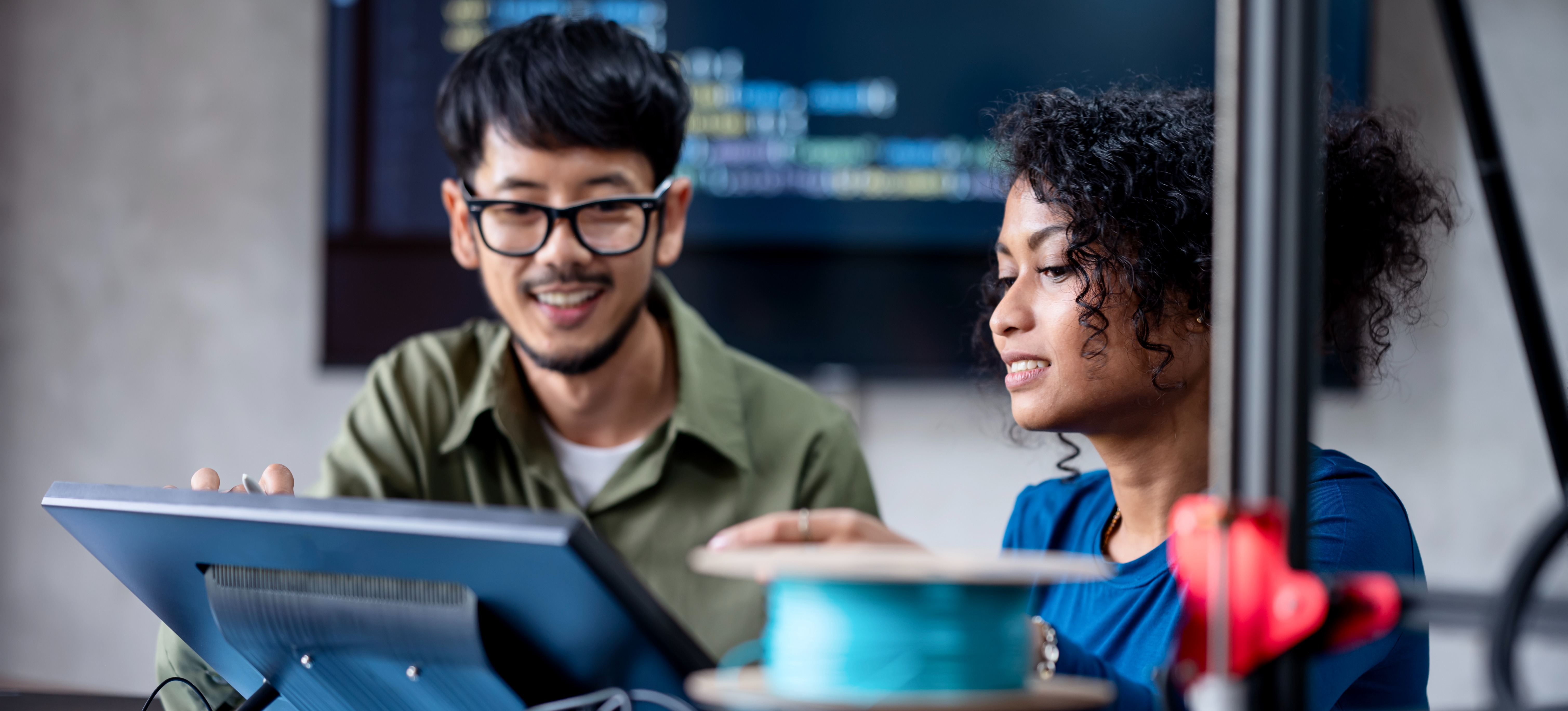 [Featured image] Two engineers looking at a small screen and discussing learning rates to train a deep learning model.