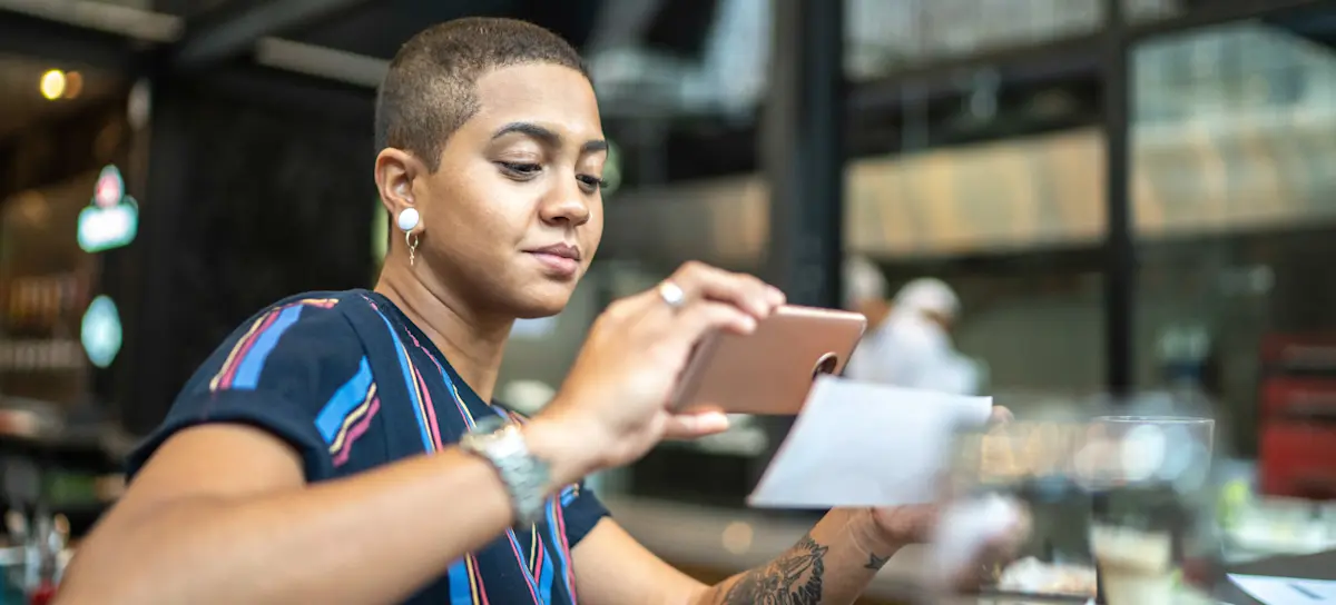 [Featured Image] An office worker is using OCR to scan a document on their phone.
