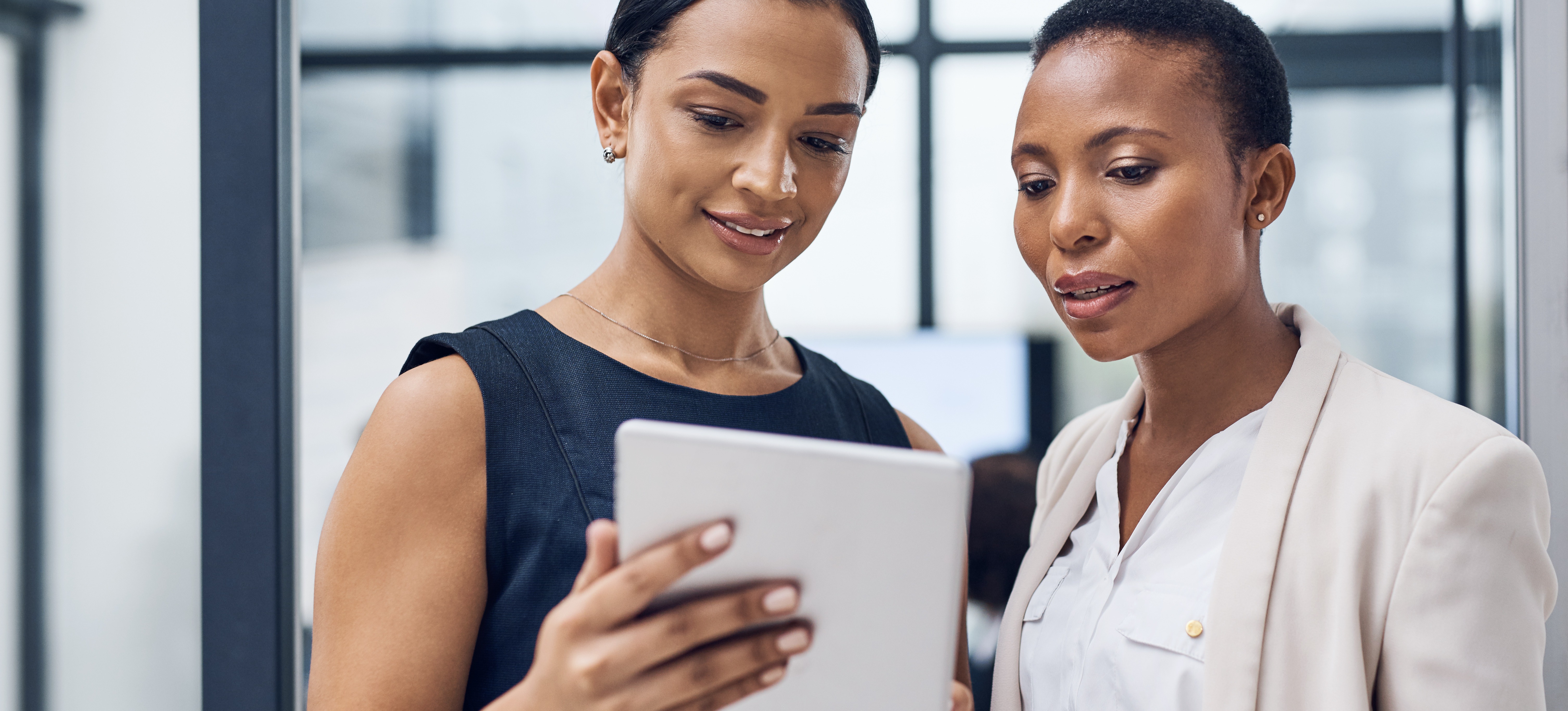[Image en vedette] Une responsable des données montre à un employé des informations sur sa tablette.
