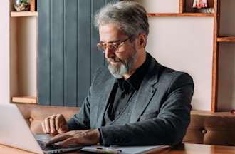 [Featured Image] A man works on a laptop. 