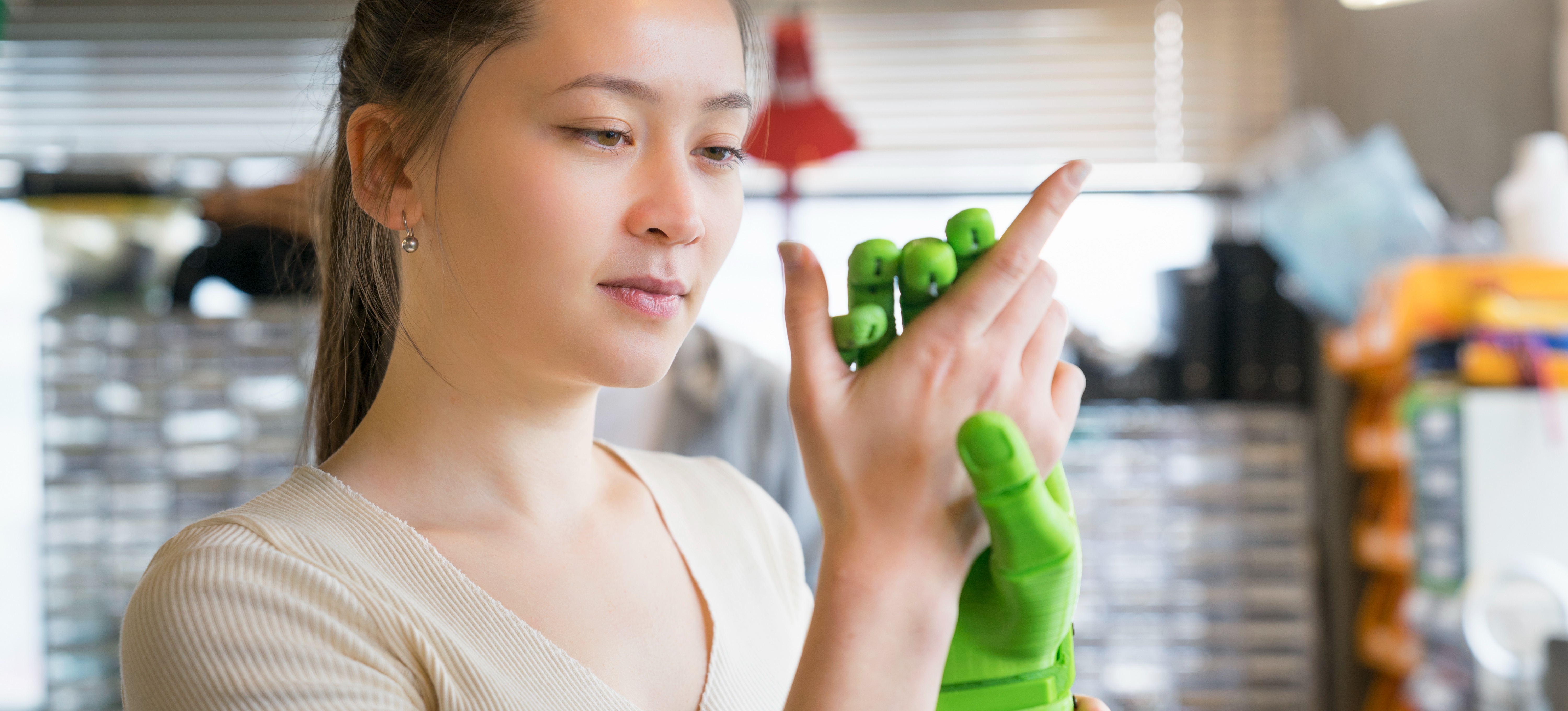 [Featured Image] An engineer examines a prosthesis model created with 3D printing in a lab setting.
