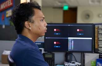 [Featured Image]:  AI Engineer, working at a desktop with multiple screens, creating computer systems.