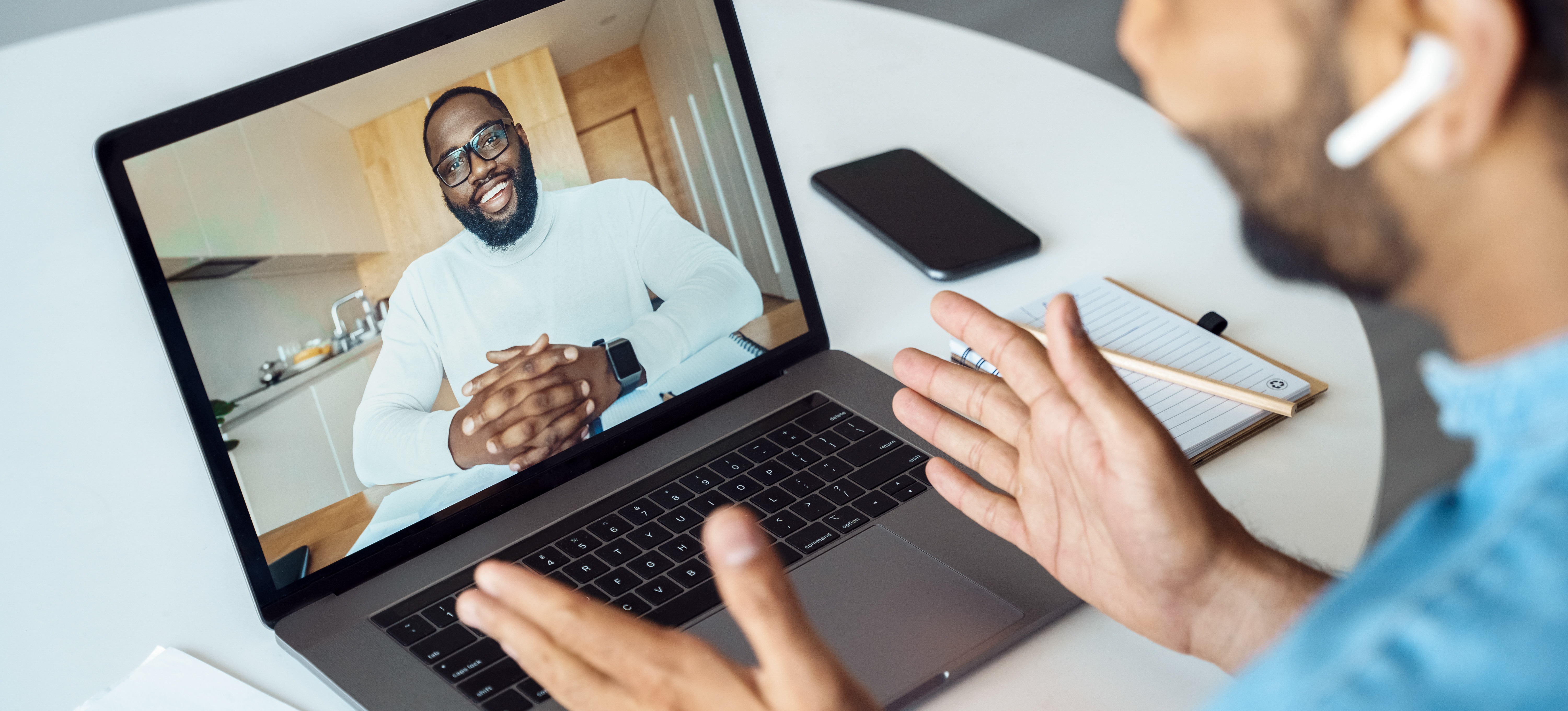 [Featured image] A person in a blue shirt and wearing AirPods uses their laptop to discuss cybersecurity interview questions on a video call. 