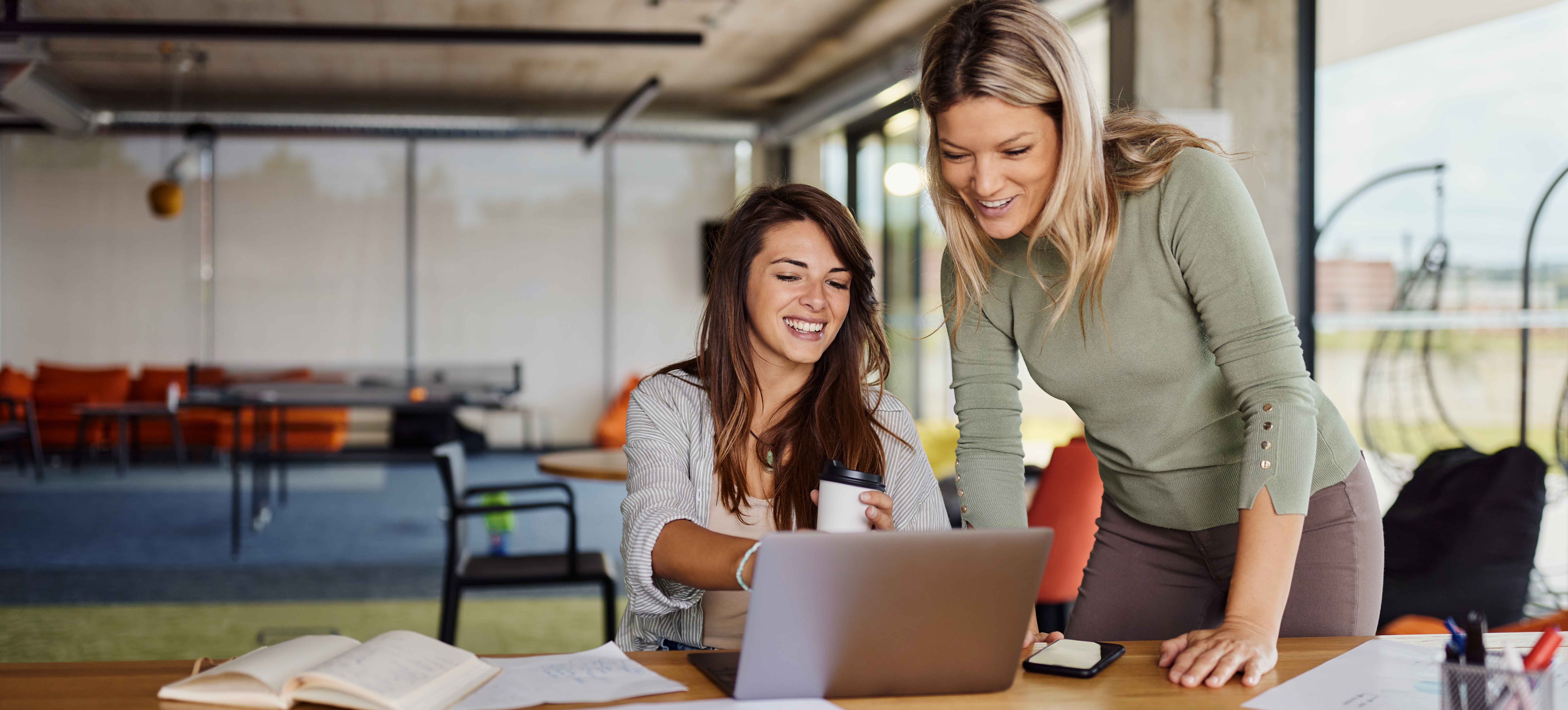 [Featured Image] Two professionals in an office setting, working on a computer, exploring the features and benefits of Microsoft 365.