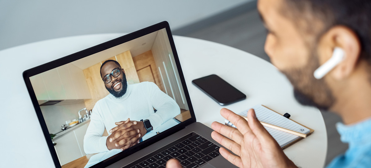 [Featured Image]:  A health coach, wearing a blue denim shirt, is having a teleconference, sitting in front of their laptop. with their client