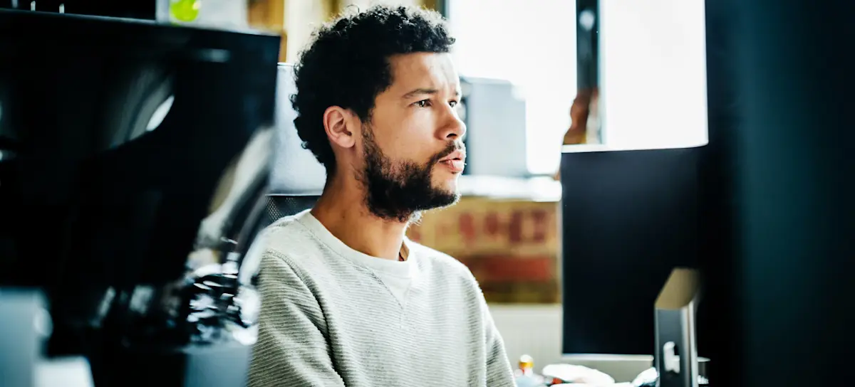 [Featured Image] A member of a development team works at a computer and performs user acceptance testing in their office.
