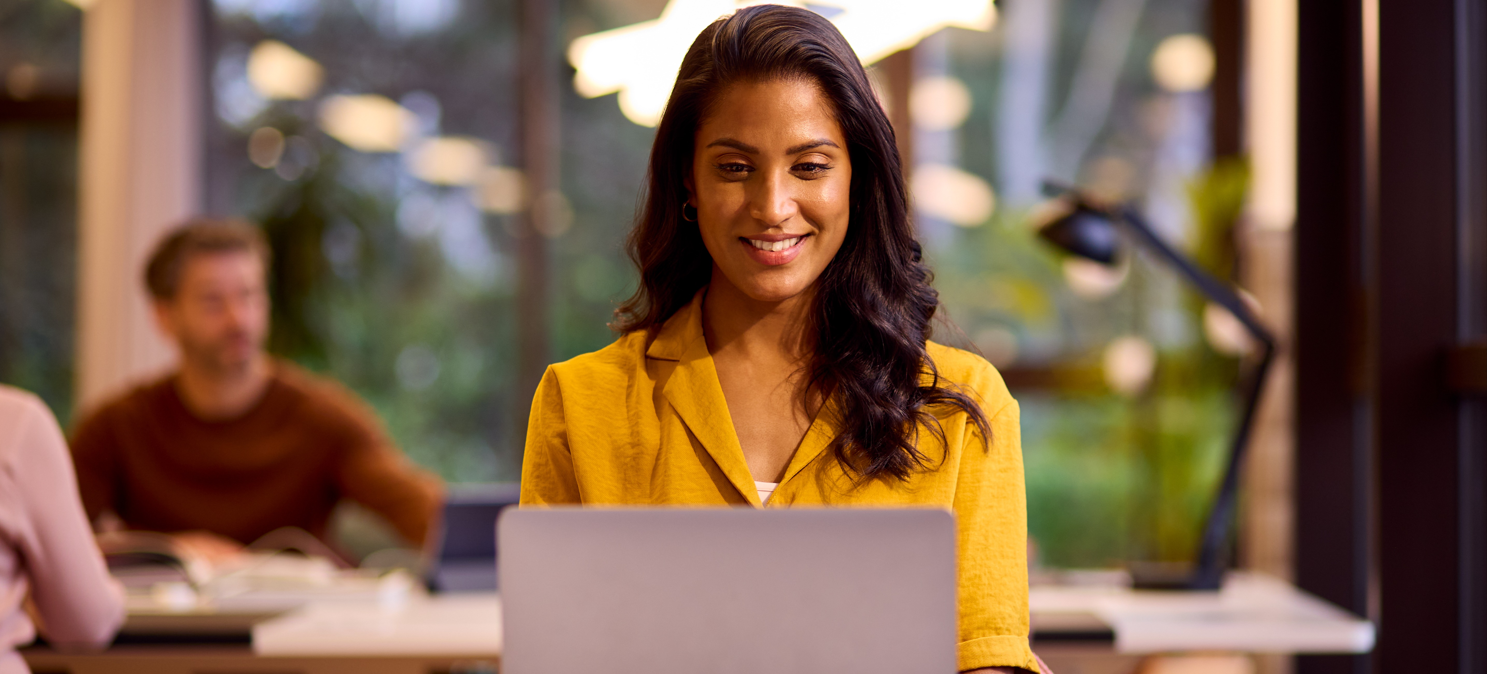 [Featured Image] An aspiring marketing professional researches the 4 Ps of marketing on their laptop in a shared study area. 
