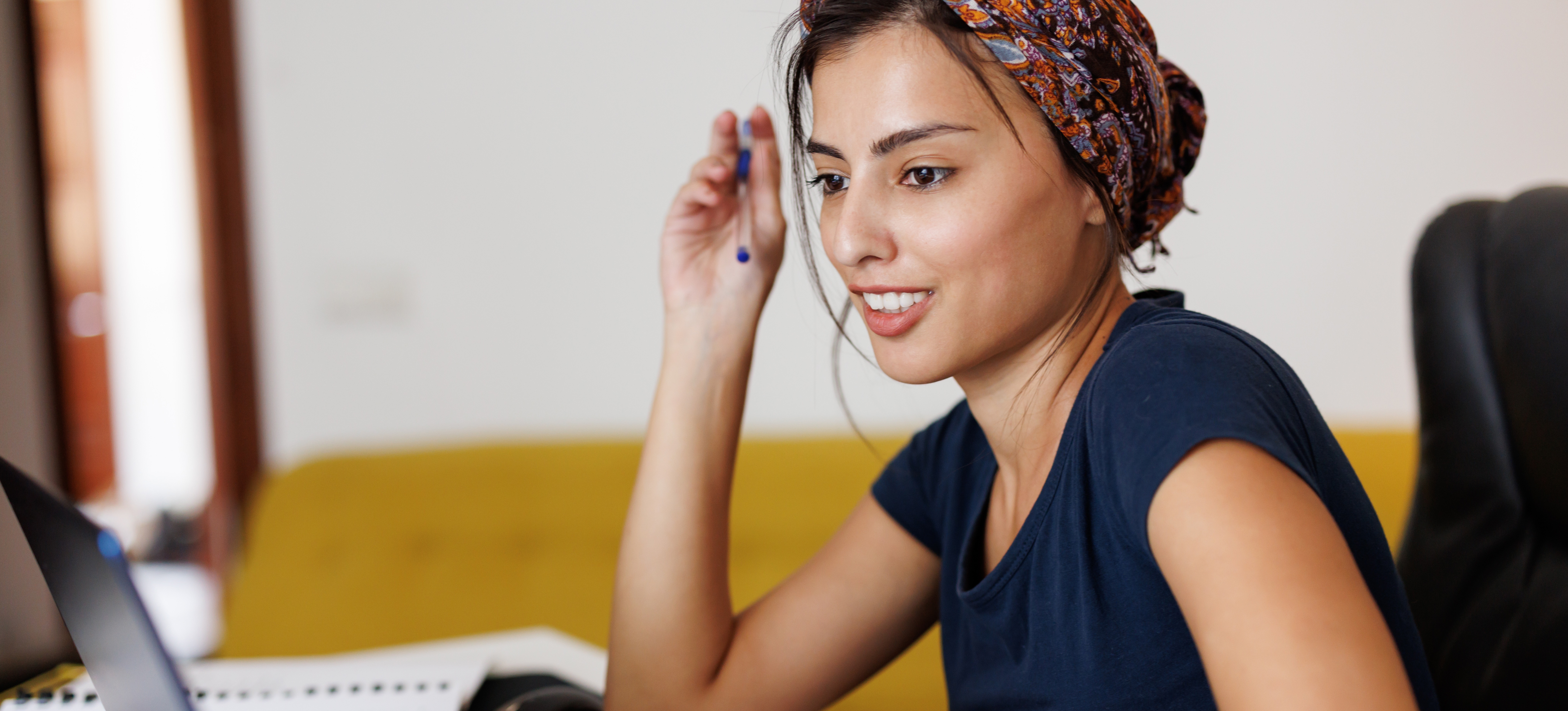 [Featured Image] A woman sits at her laptop and works on a job acceptance letter. 