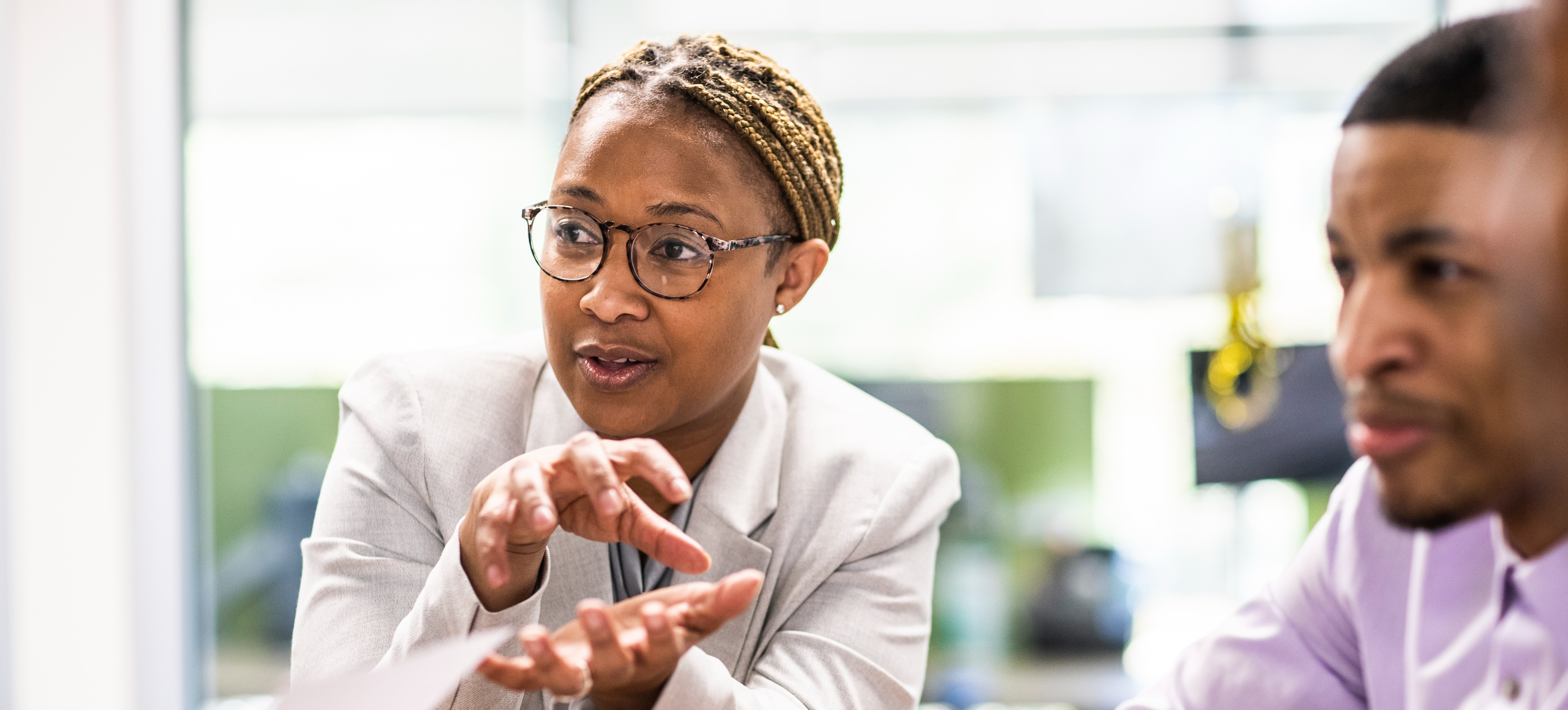 [Featured Image] A business advisor, who completed a business management degree, presents their analysis and ongoing strategy to company leaders. 
