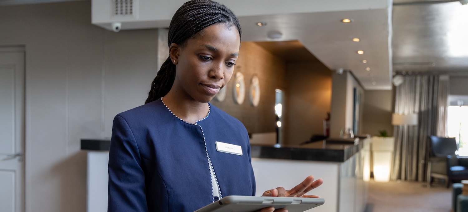 [Featured Image] A hotel manager prepares for guests to check in.

