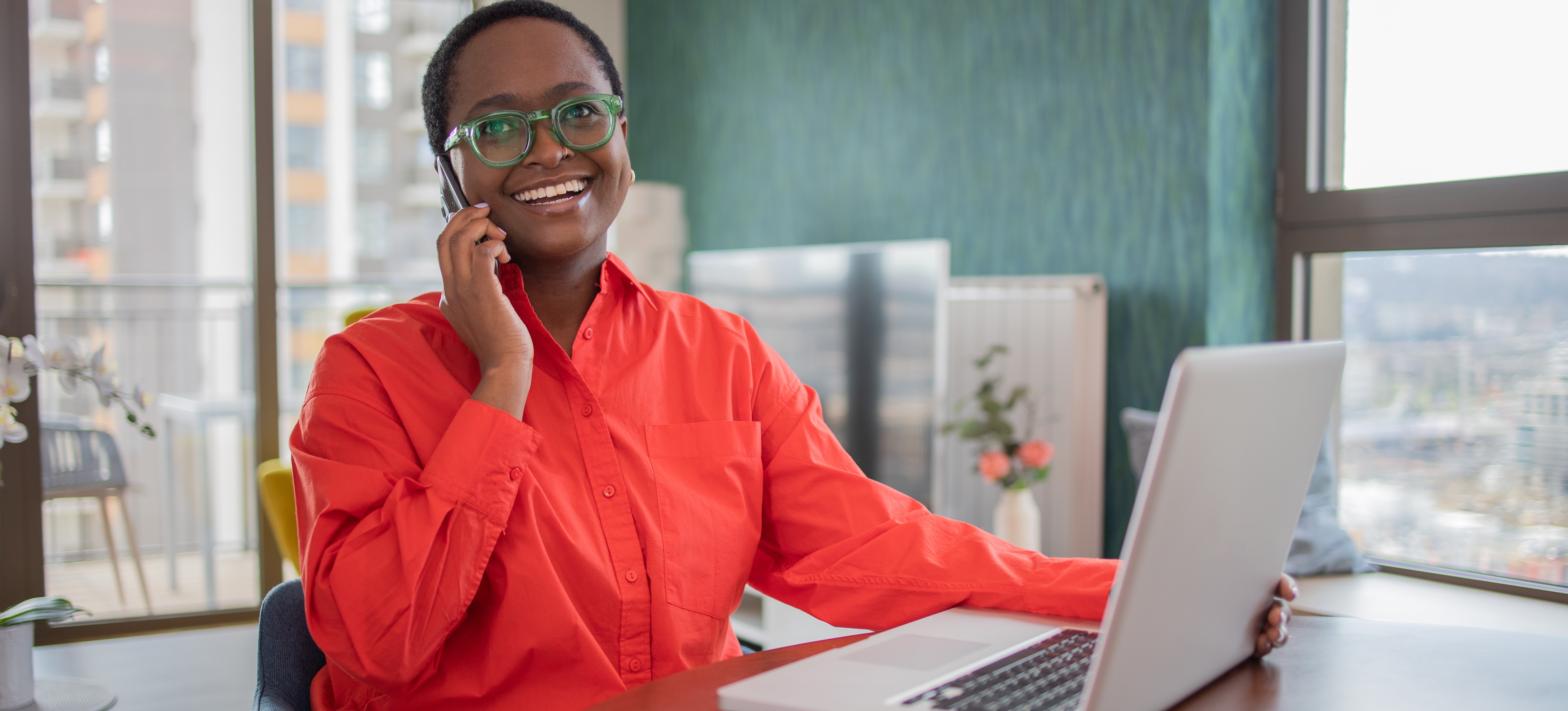 [Featured Image] A professional works on a laptop and talks on the phone, utilizing Microsoft Copilot to aid productivity.
