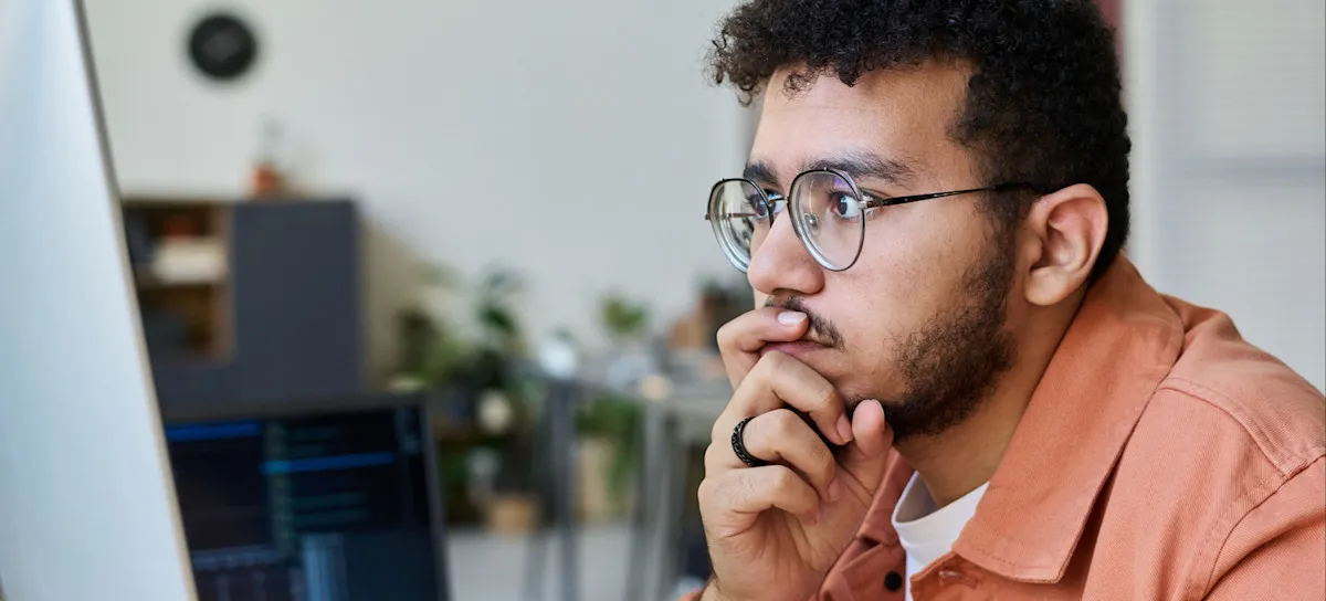 [Featured Image] An app developer works at a computer, utilizing Swift as their preferred iOS development programming language.

