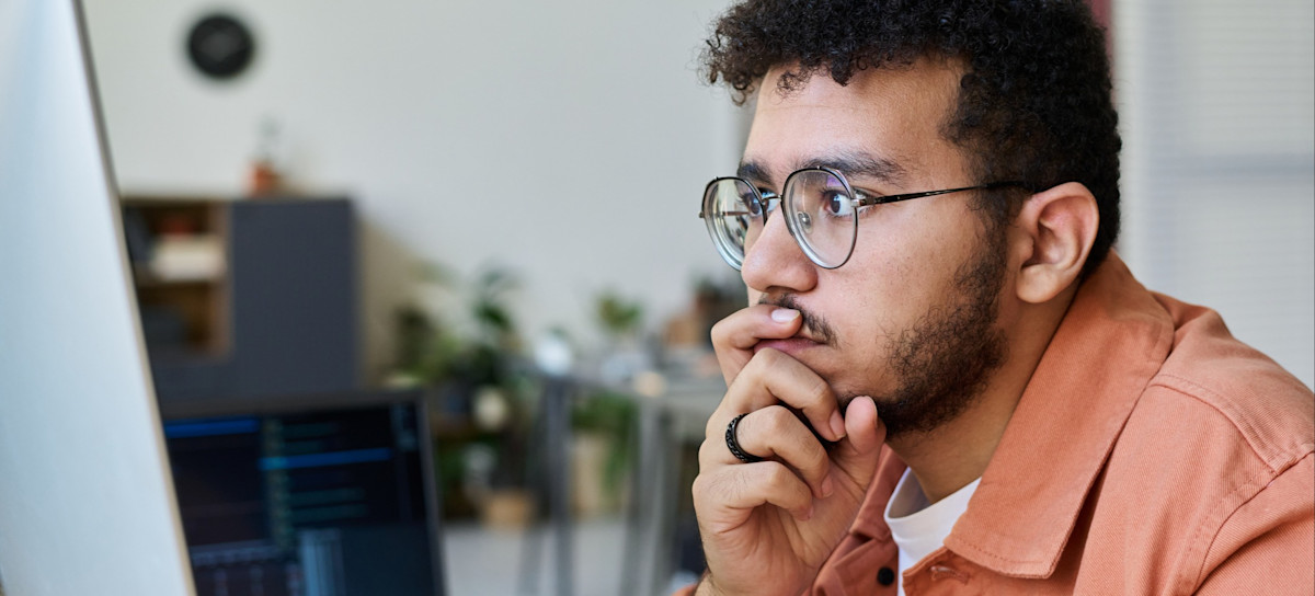 [Featured Image] An app developer works at a computer, utilizing Swift as their preferred iOS development programming language.
