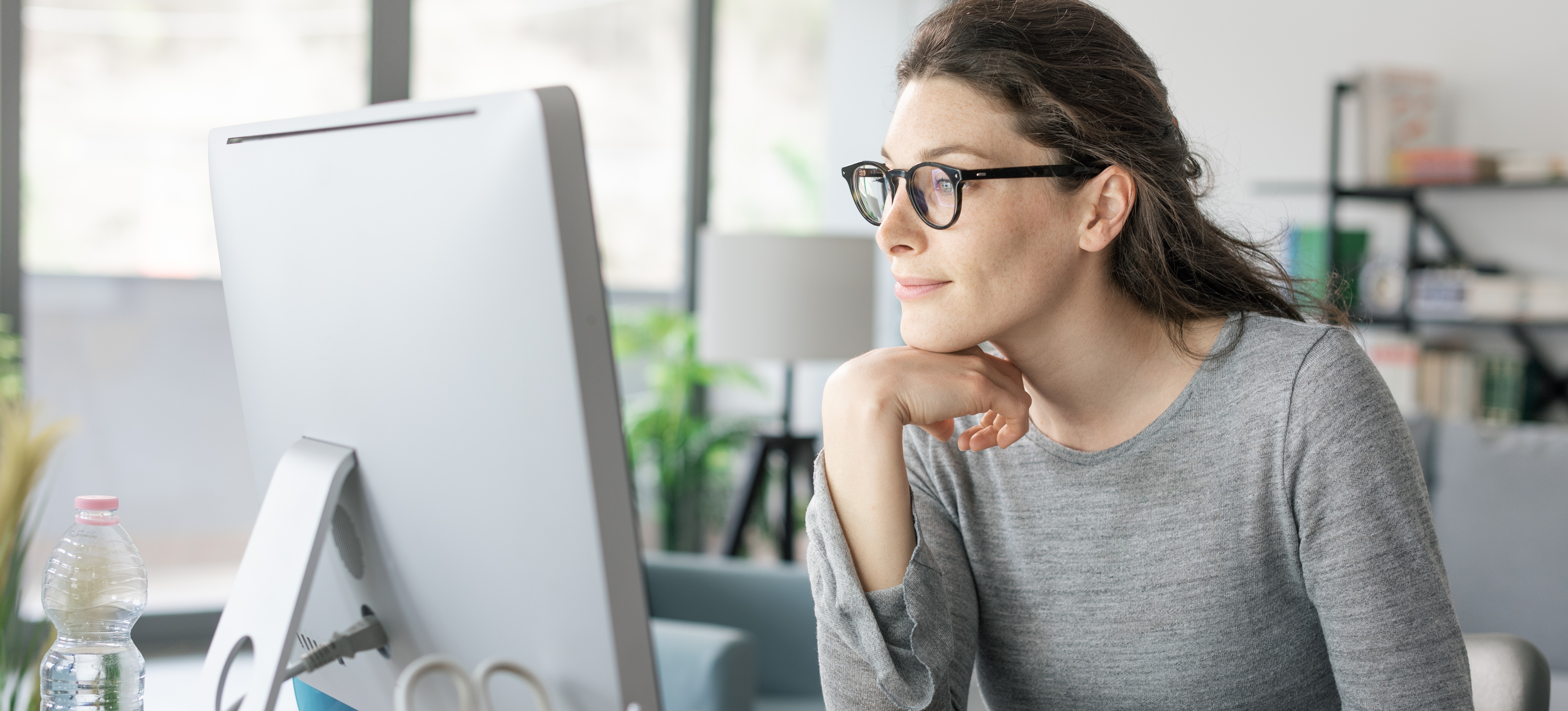 [Hauptbild] Ein lächelnder Fachmann verbessert seine Datenkompetenz, während er vor einem Computerbildschirm sitzt.