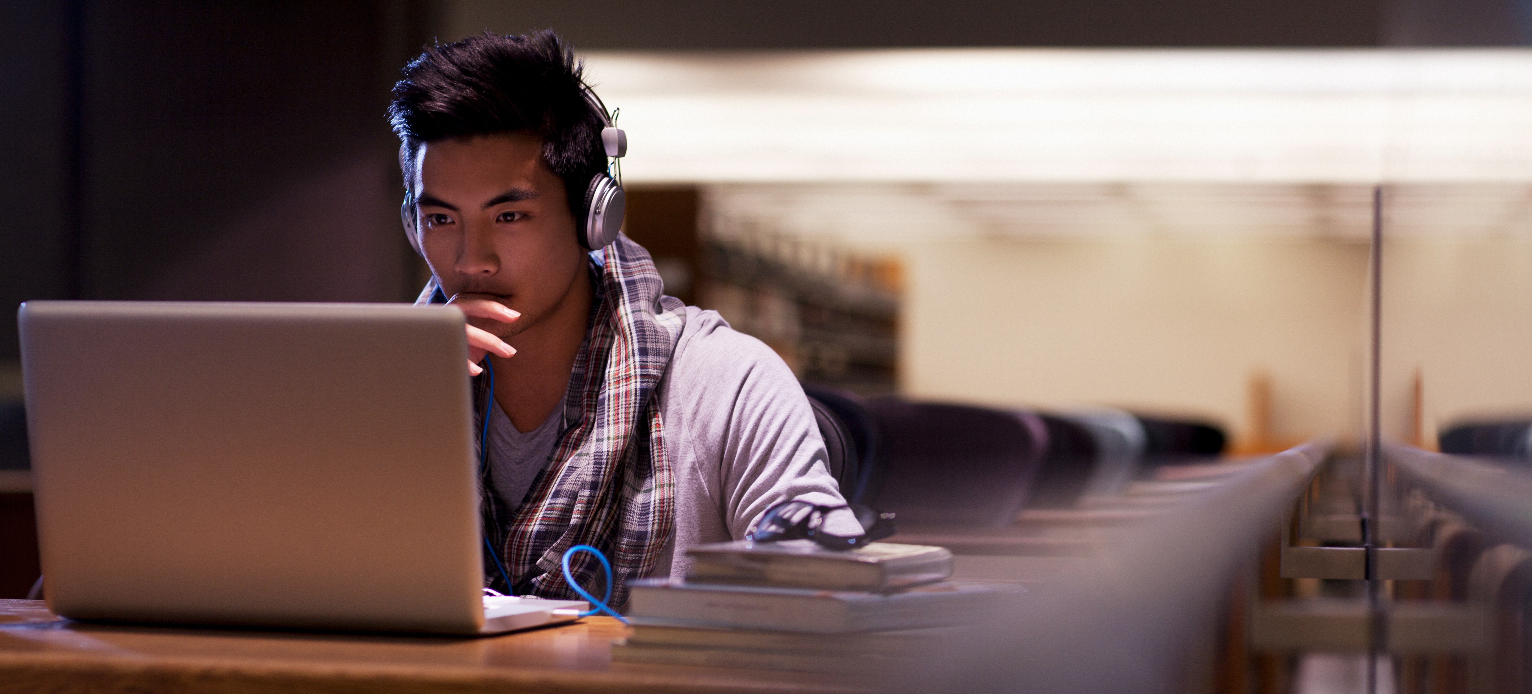 [Featured image] A young professional is seen working on his laptop. 