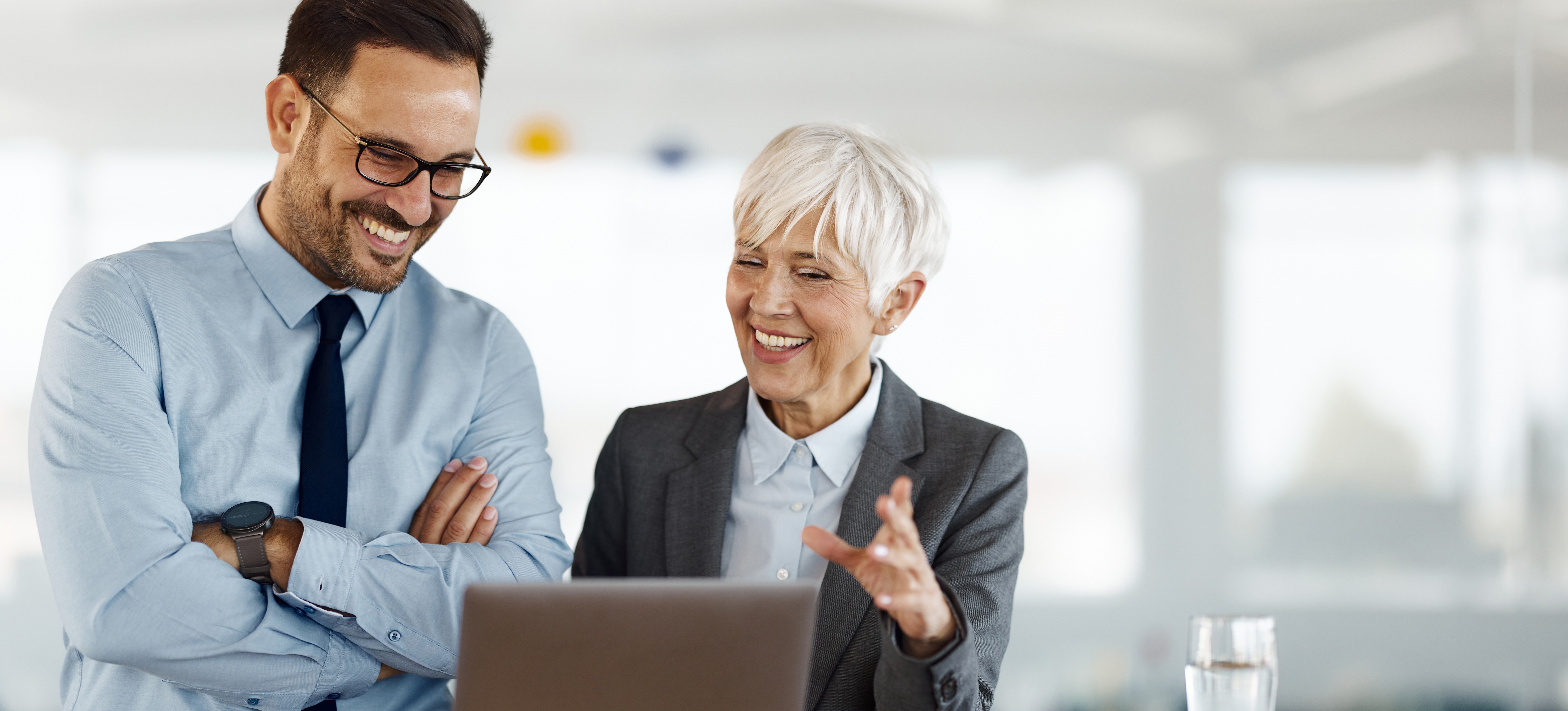 [Featured Image] Two corporate colleagues discuss the company’s organizational leadership and how to develop leadership skills as part of their company-wide professional development program.

