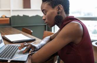 [Featured image] A woman sits at a laptop examining a SERP (search engine results page).