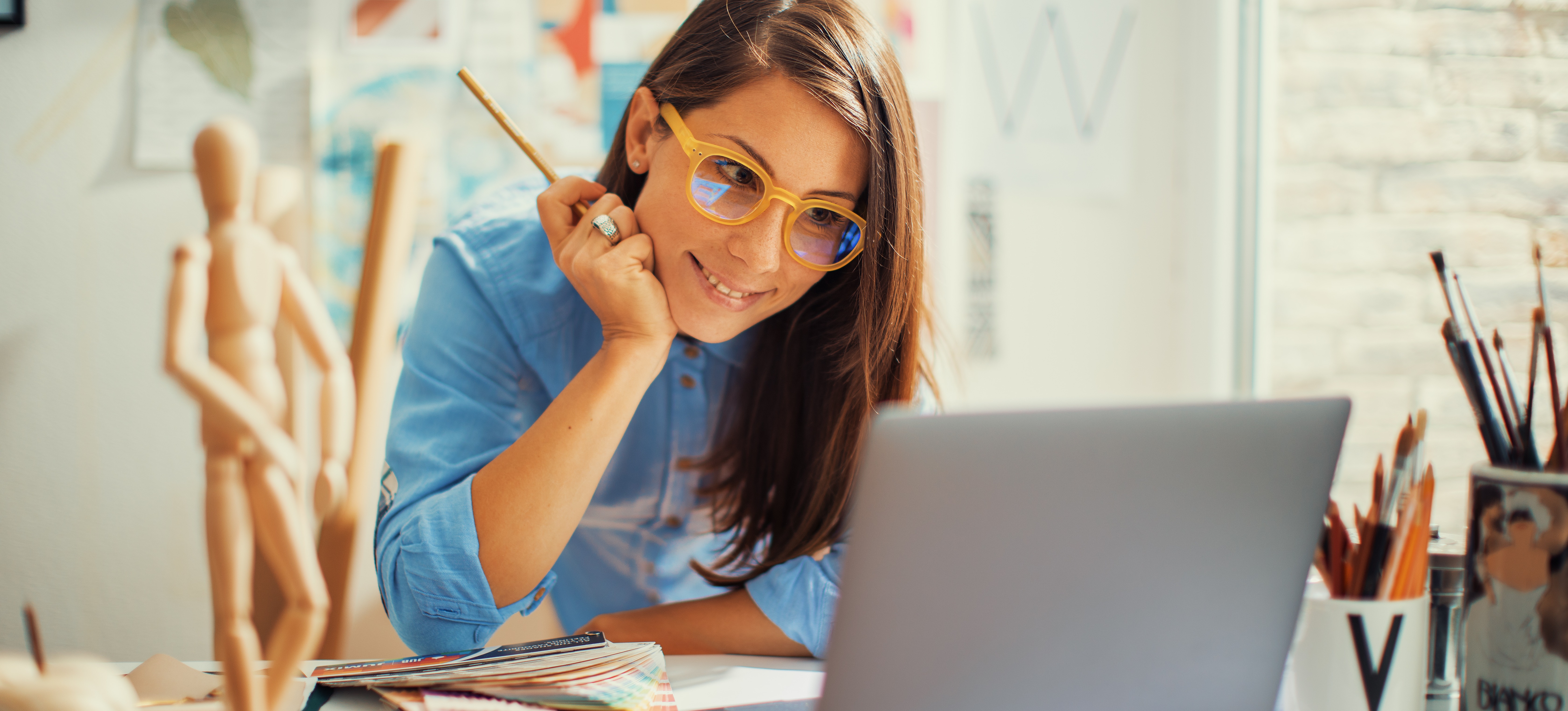 [Featured Image] An information designer works on a project from their desk in their home office. 