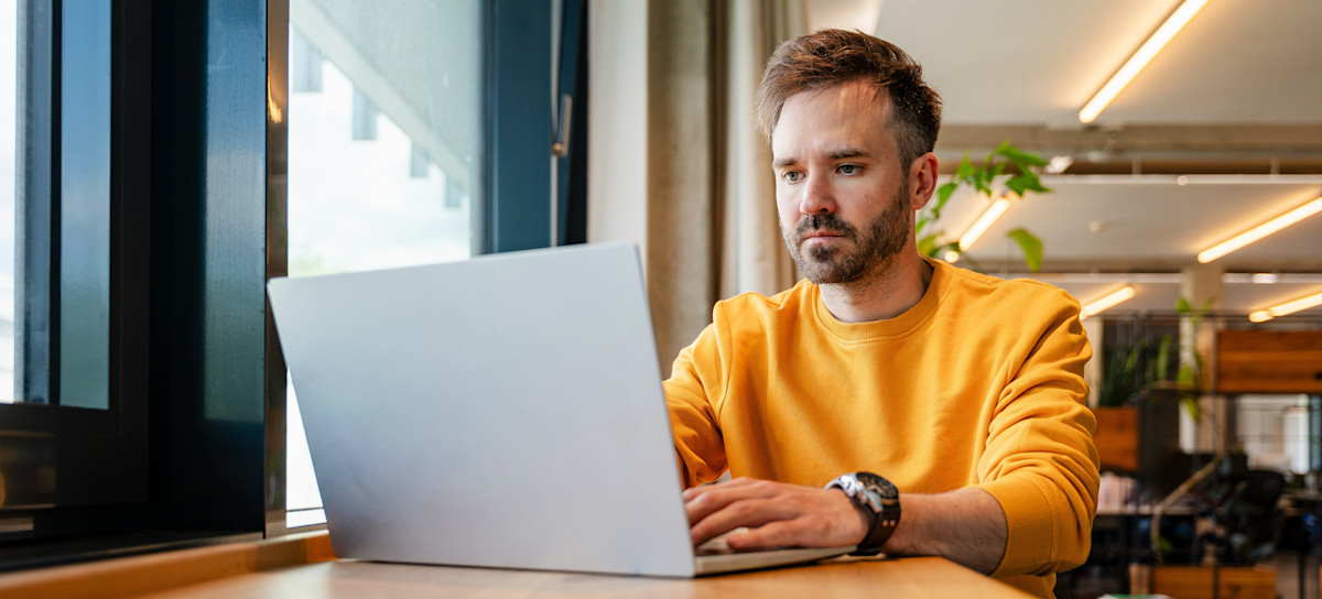 [Featured Image] A businessperson learning how to use a DNS lookup command works on their laptop as they complete coursework for an online class. 
