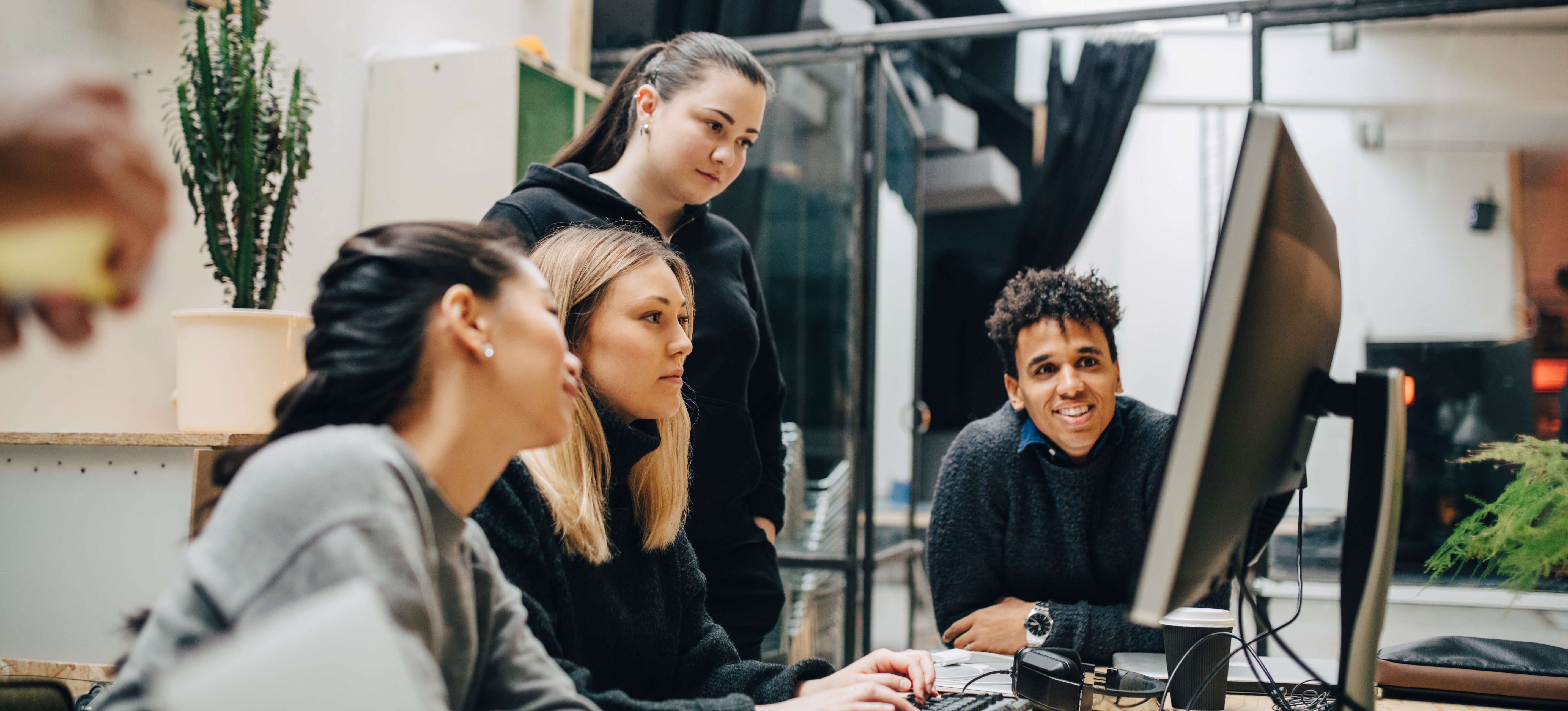 [Featured image] A team of content writers in an office discussing openai playground vs chat gpt for their next project.