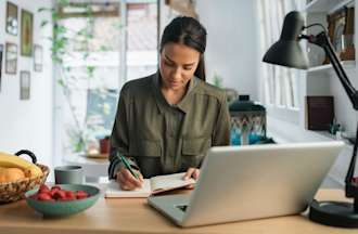 [Featured Image] A woman searching for a creative job works at her desk. 