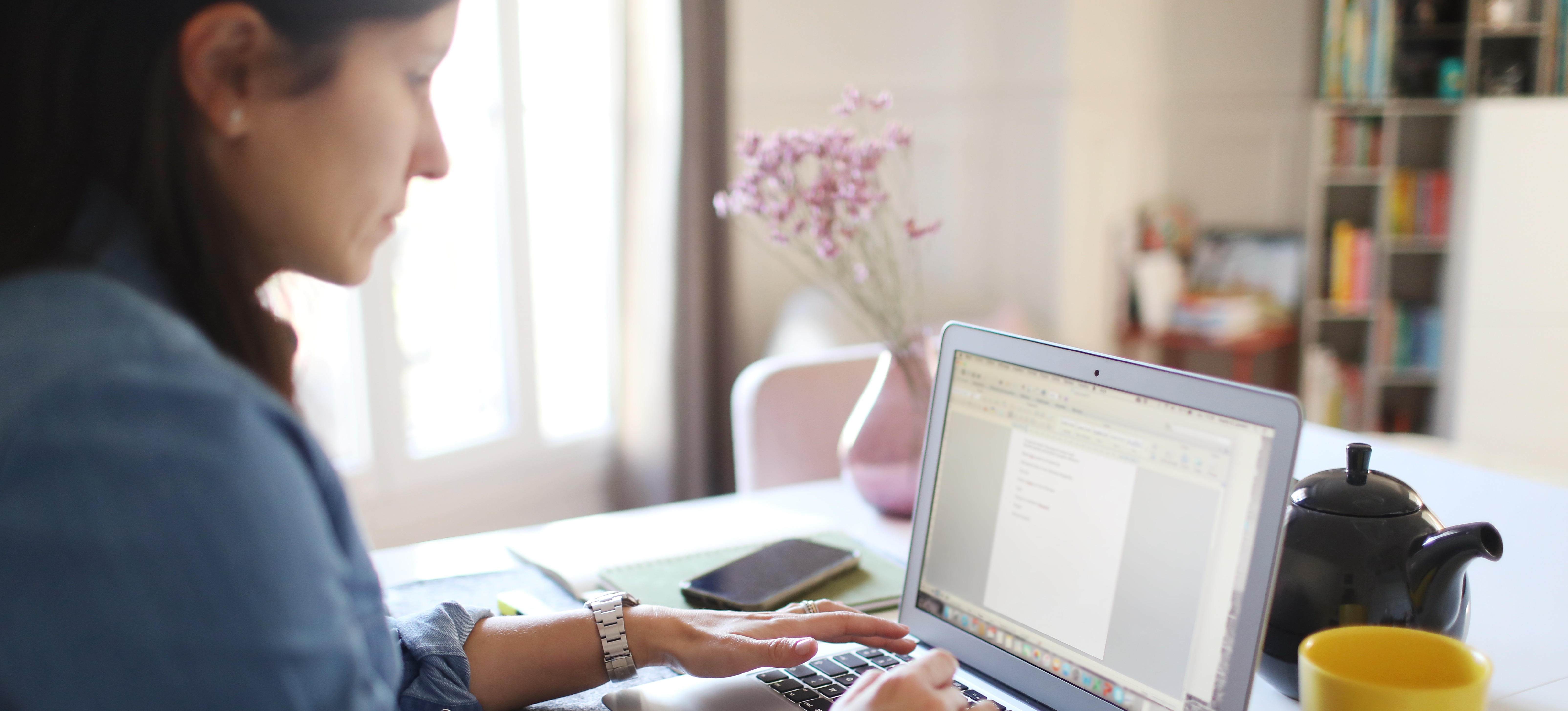 [Featured Image] A person on their laptop at home is creating their resume for work using Excel.
