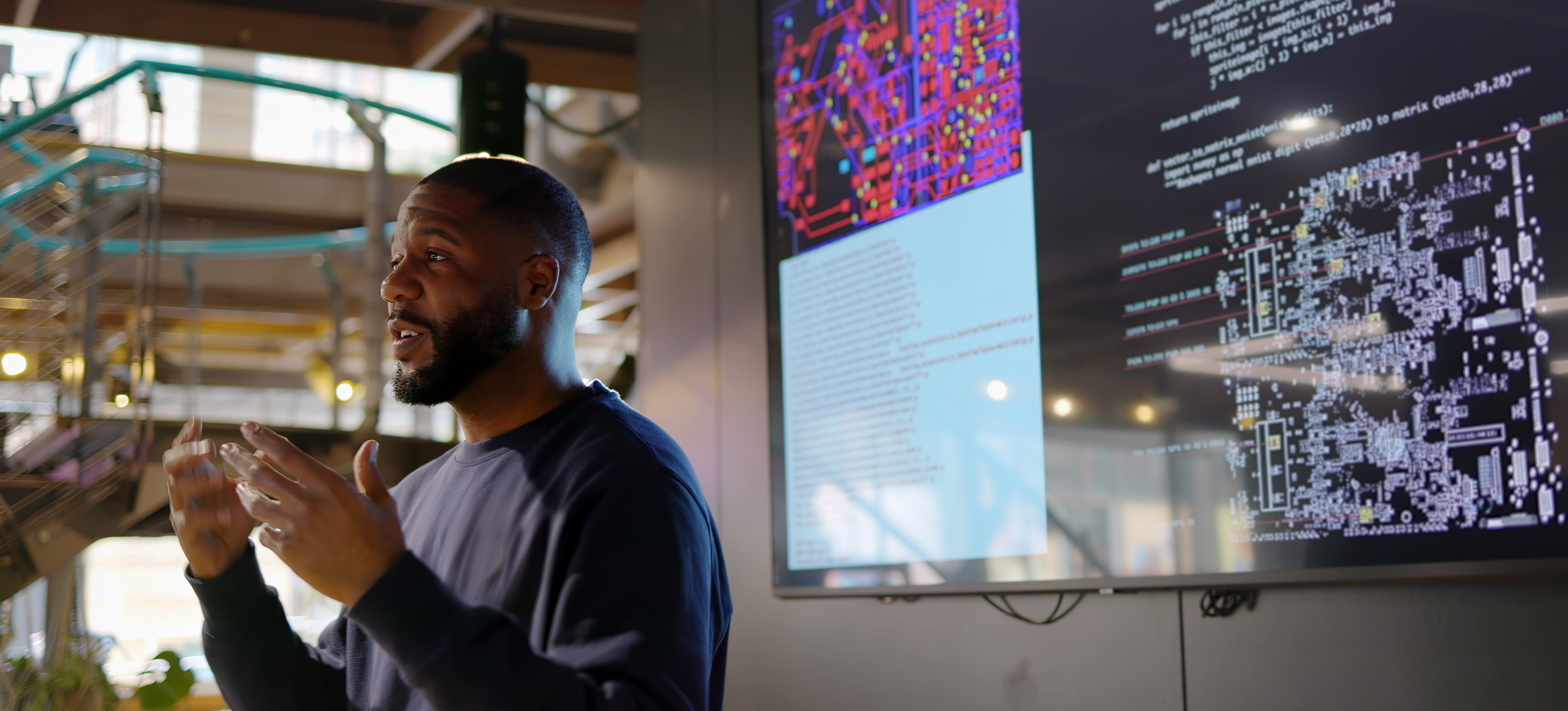 [Featured Image]: A speaker stands in front of a monitor and addresses a group of programmers about the benefits of R programming certification.
