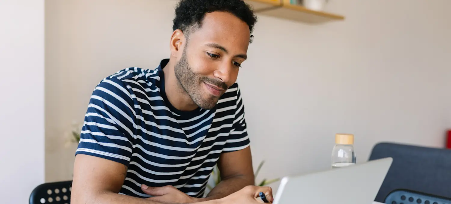 [Featured image] A person sits at a laptop in their home and explores a potential Linux career path for their future.
