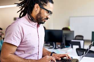 [Featured Image] A fintech engineer works on their code on a laptop to ensure the organization's digital banking platform runs smoothly. 
