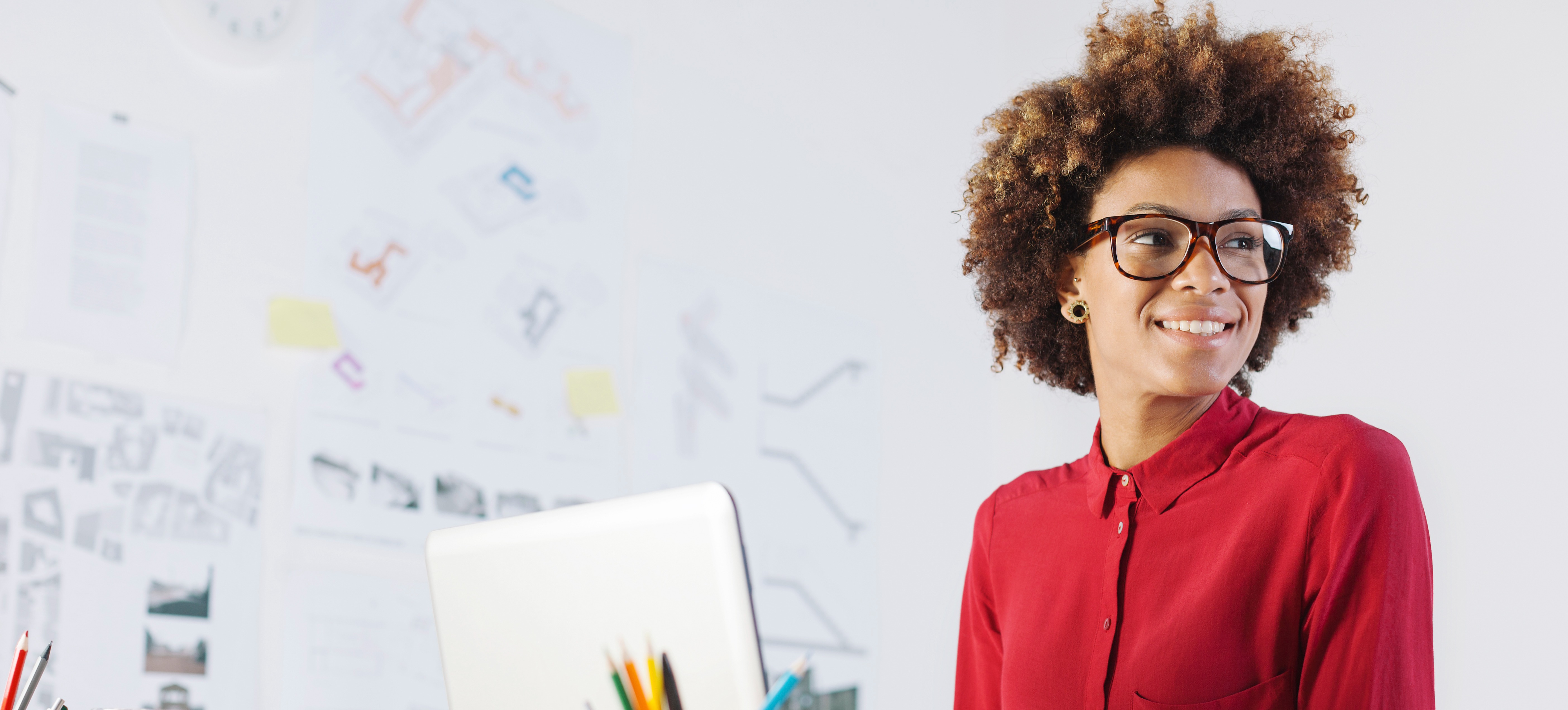 [Featured Image] A smiling business leader working at her computer.
