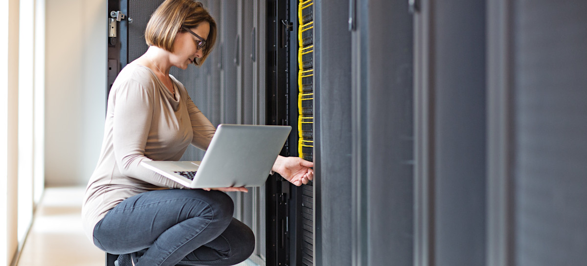 [Featured image] An employee holding a laptop visits their company's big data storage warehouse.