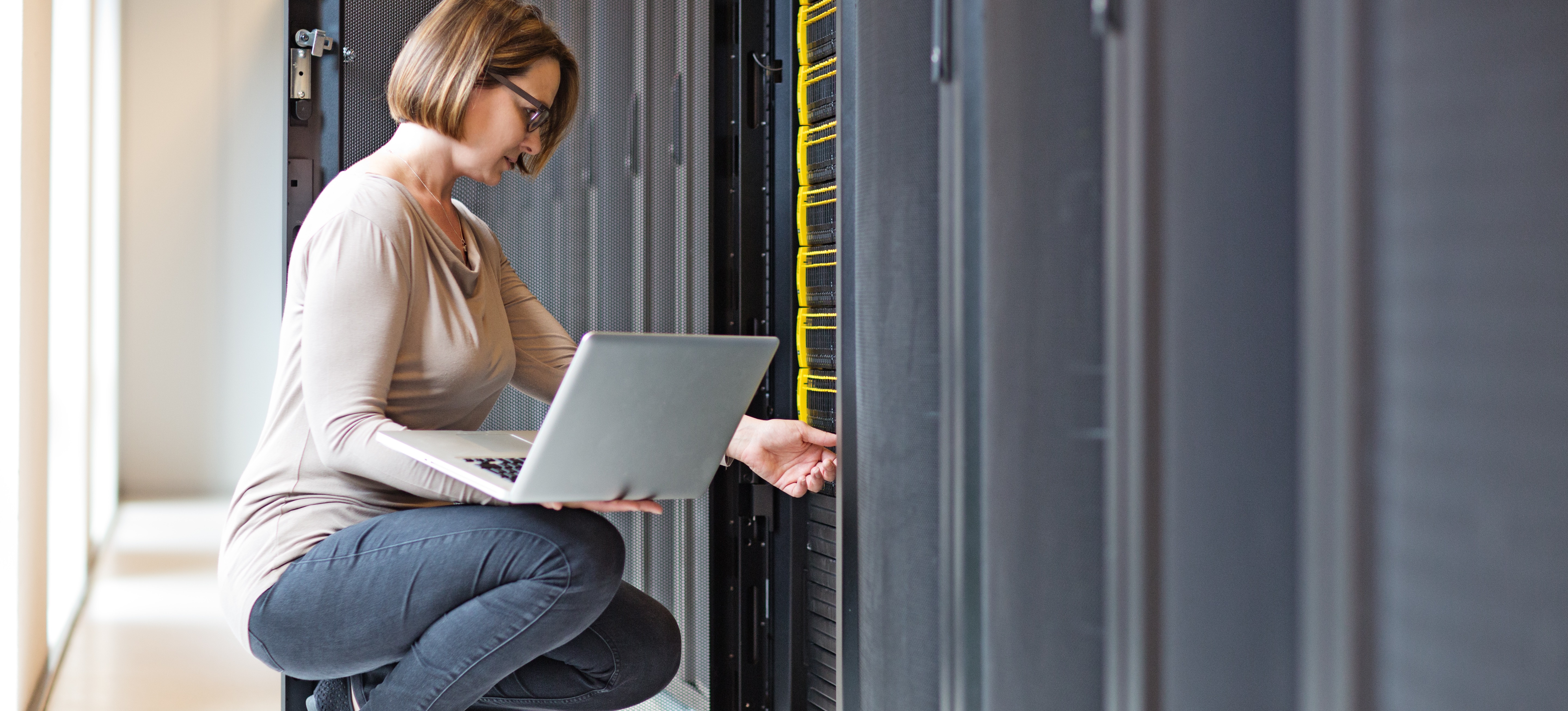 [Featured image] An employee holding a laptop visits their company's big data storage warehouse.