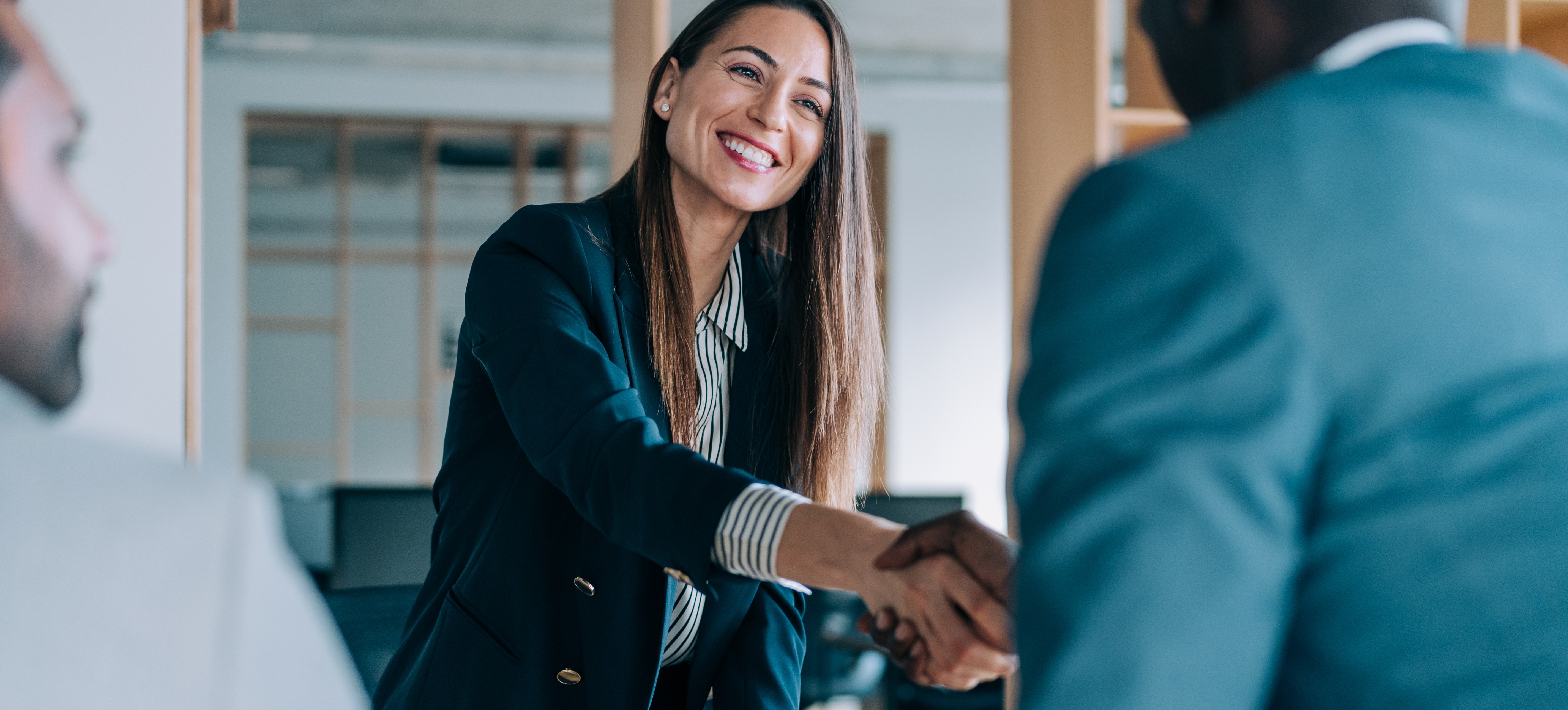 [Featured Image] A woman shakes hands with a potential employer after completing a round of Tableau interview questions.
