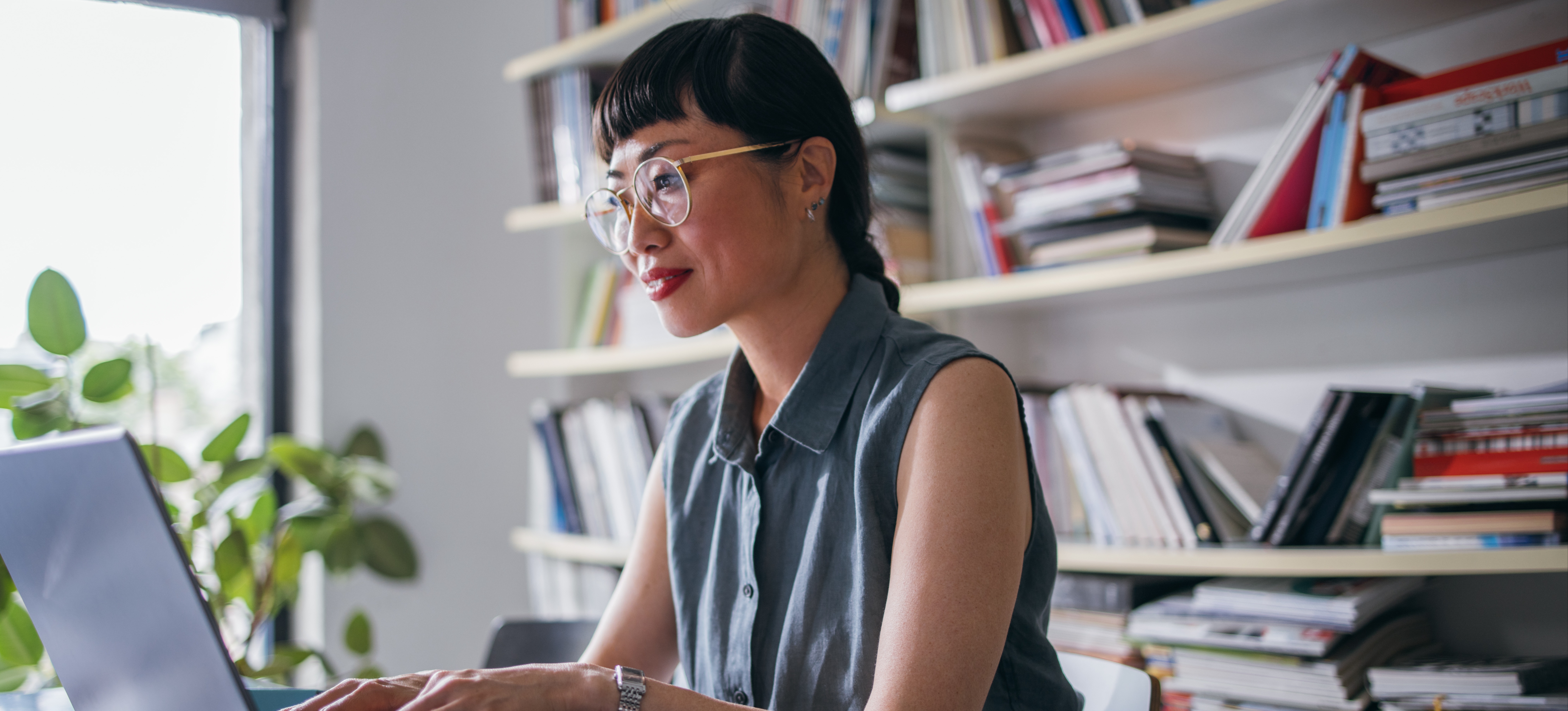 [Image en vedette] Un homme d'affaires qui s'investit dans la culture de l'apprentissage au sein de son entreprise suit une formation sur son ordinateur portable, assis dans son bureau devant une étagère remplie de livres.