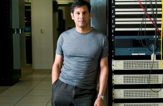 [Featured image] A person in a gray t-shirt leans against a shelf in a server room.