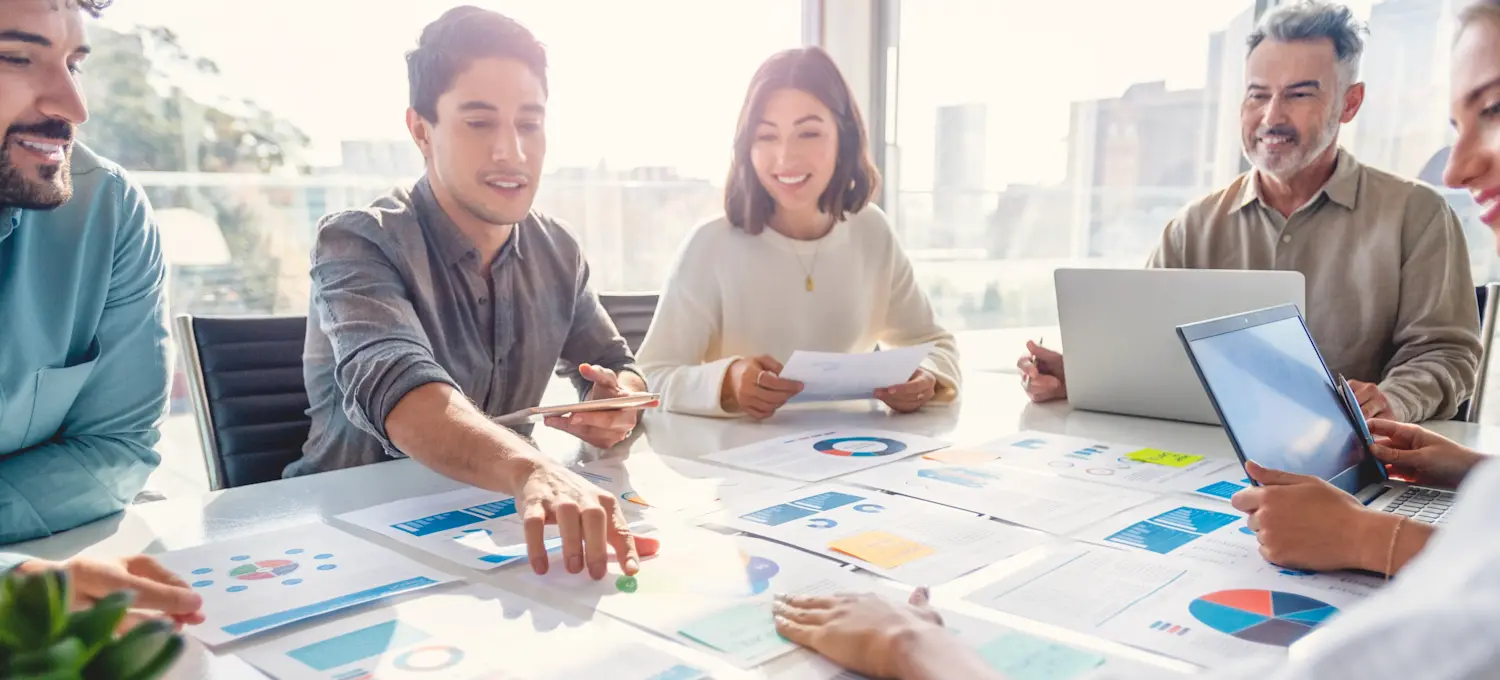 [Featured Image]: A group of people sitting around a table apply quantitative analysis methods to review customer data.
