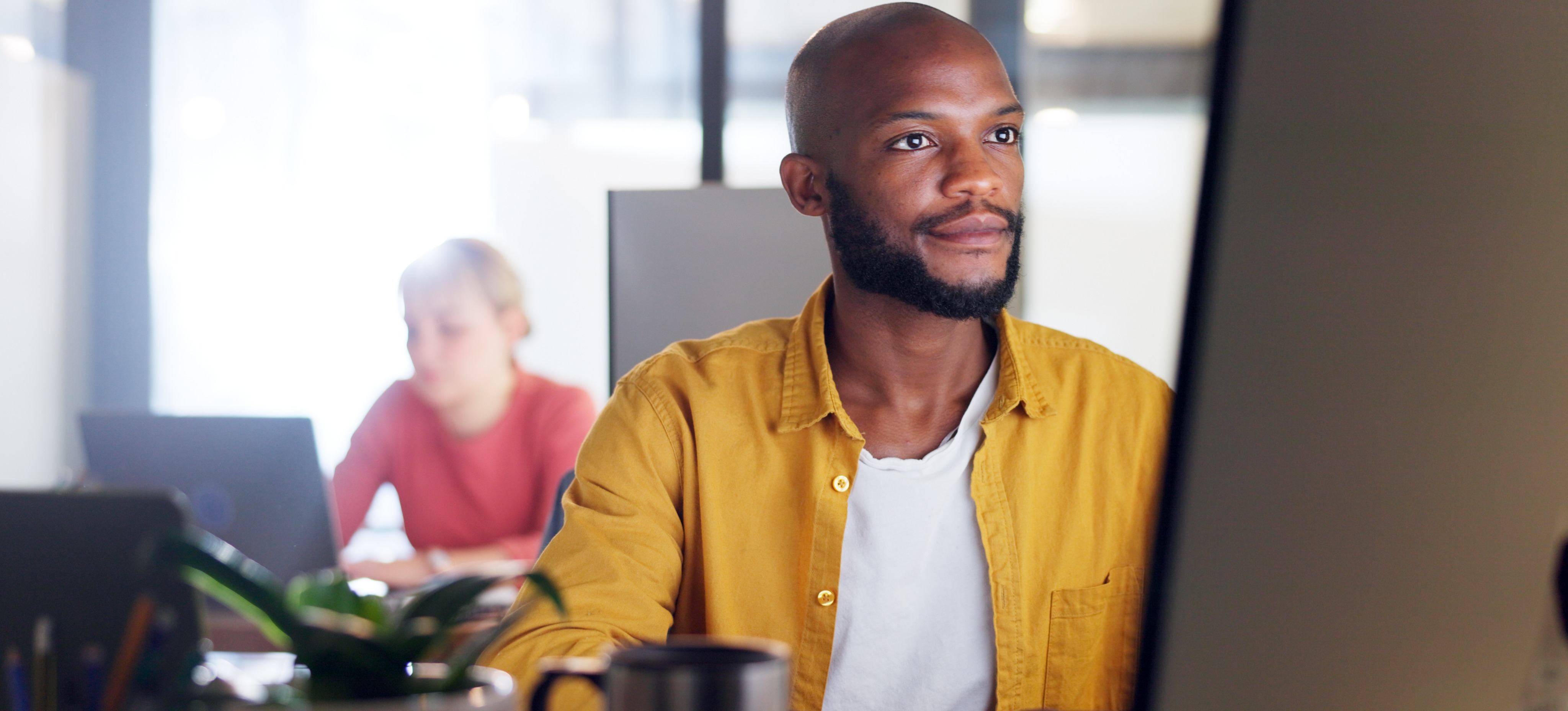 [Featured Image] A front-end developer works on a computer in an office setting.
